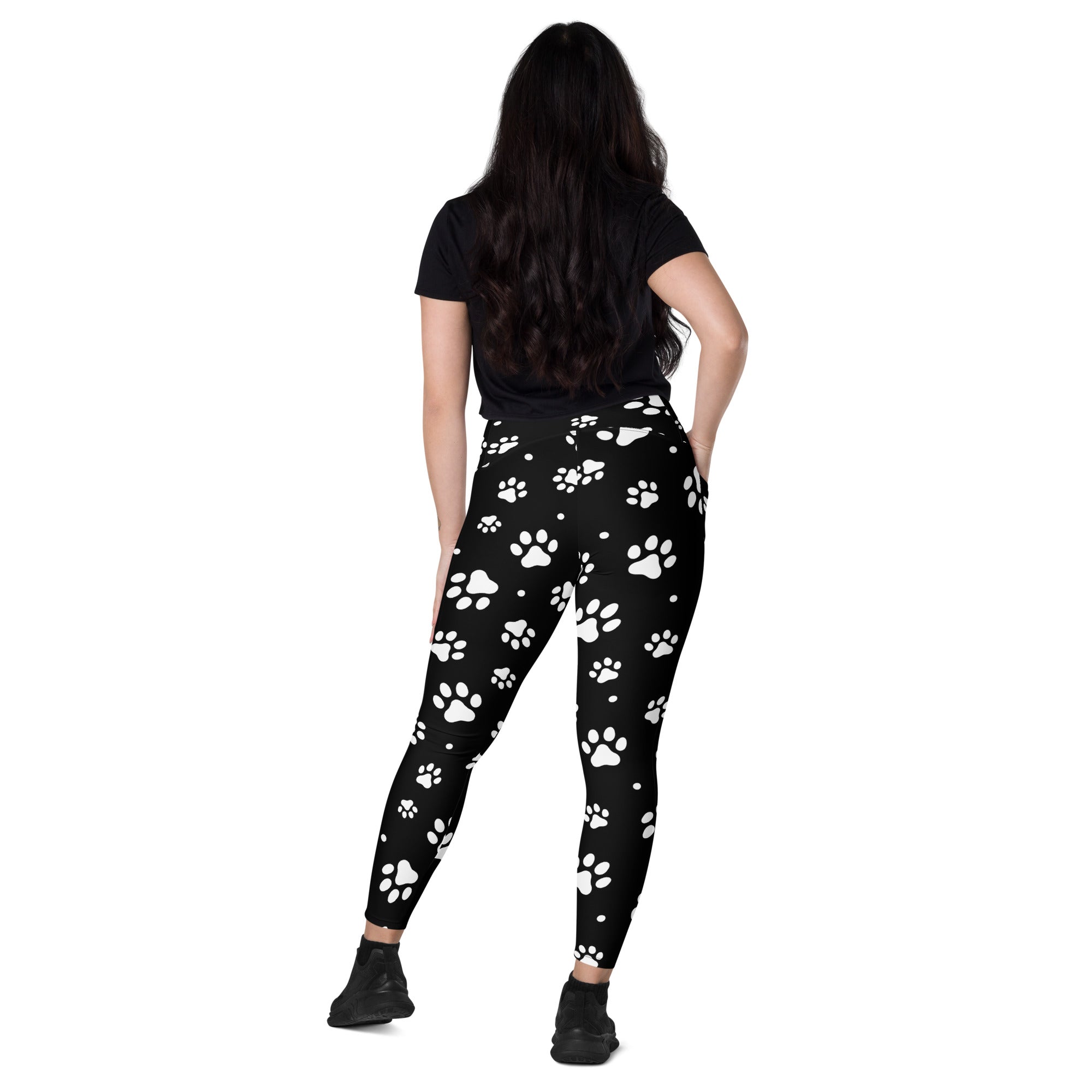 Women’s black high-waisted paw print yoga leggings with pockets featuring white paw print pattern and soft compression fabric