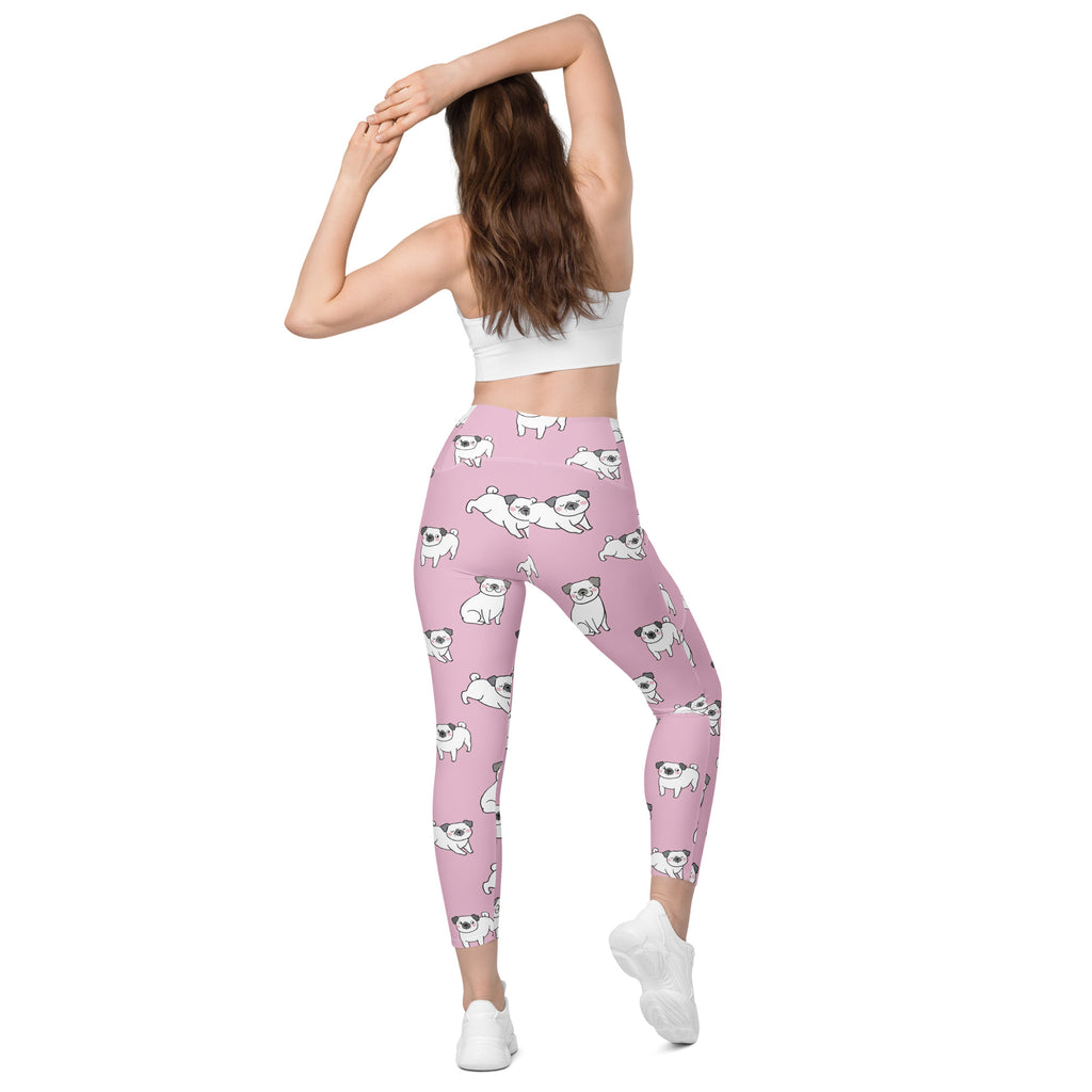 Women’s pink high-waisted pug yoga leggings with pockets featuring a repeating white pug pattern and soft compression fabric