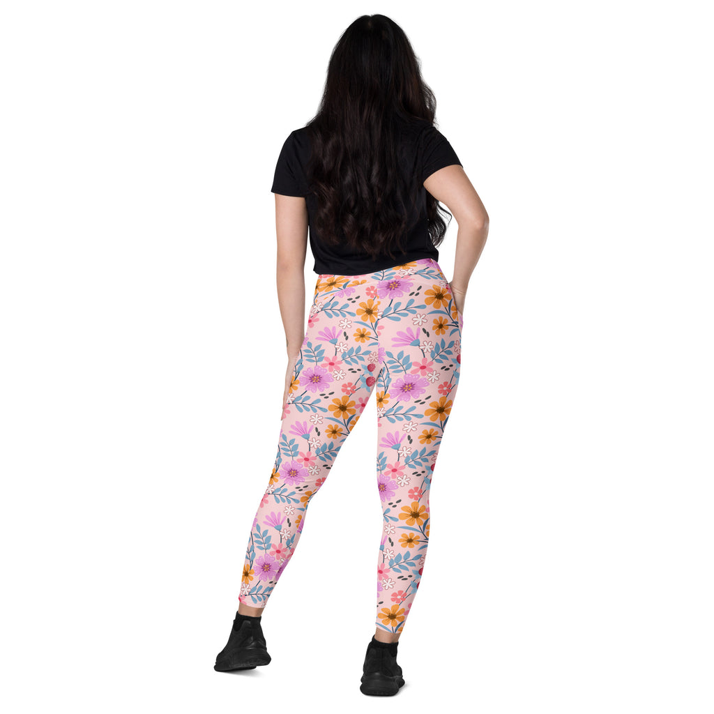 Women’s pink floral yoga leggings with pockets featuring vibrant pink orange and blue flower and leaf pattern