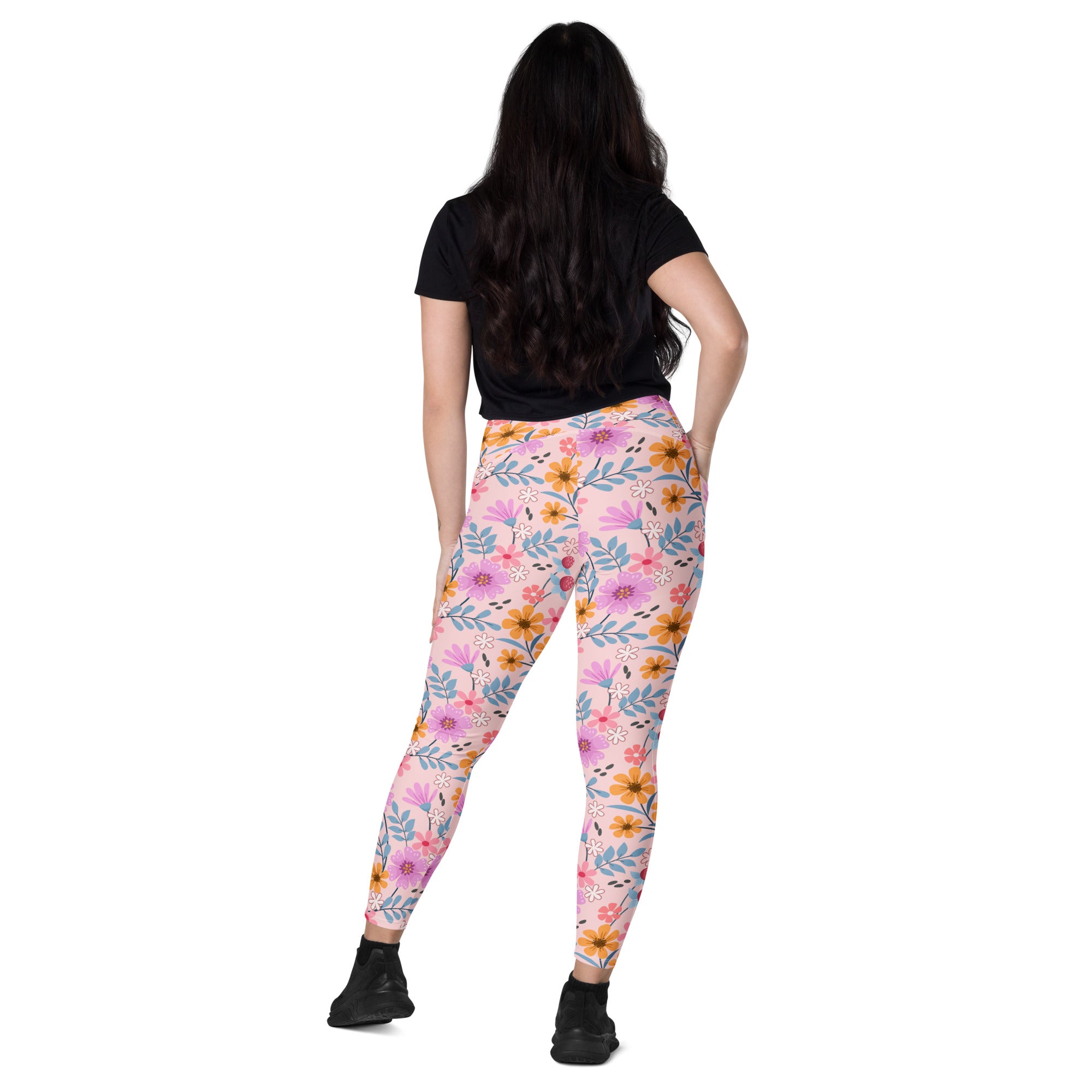 Women’s pink floral yoga leggings with pockets featuring vibrant pink orange and blue flower and leaf pattern