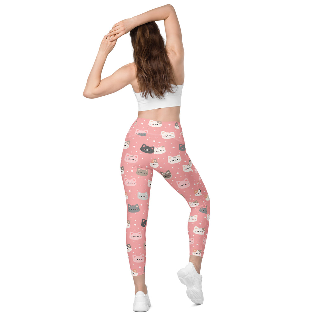 Women’s pink high-waisted yoga leggings with playful multicolor cartoon cat faces and soft compression fabric with pockets
