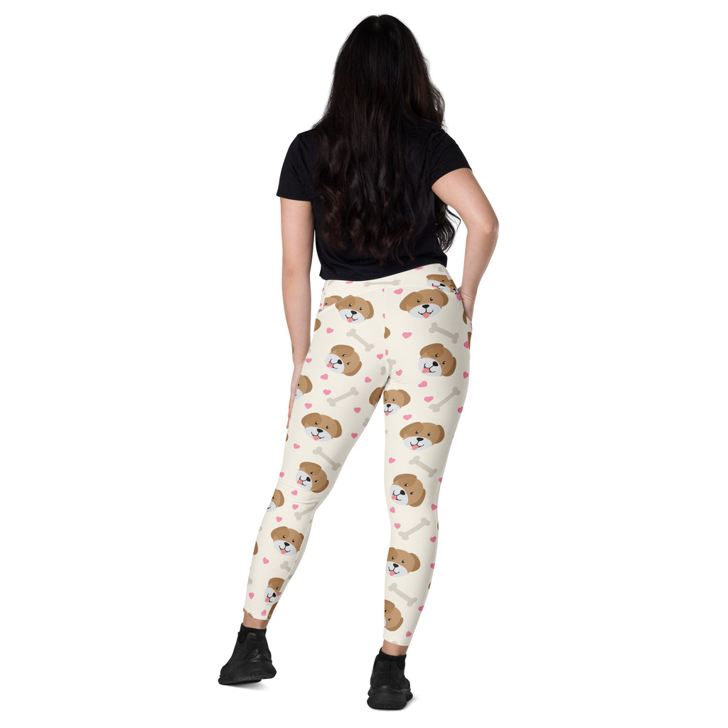 Cream-colored women’s high-waisted dog yoga leggings with pockets featuring brown puppy faces pink hearts and white bones