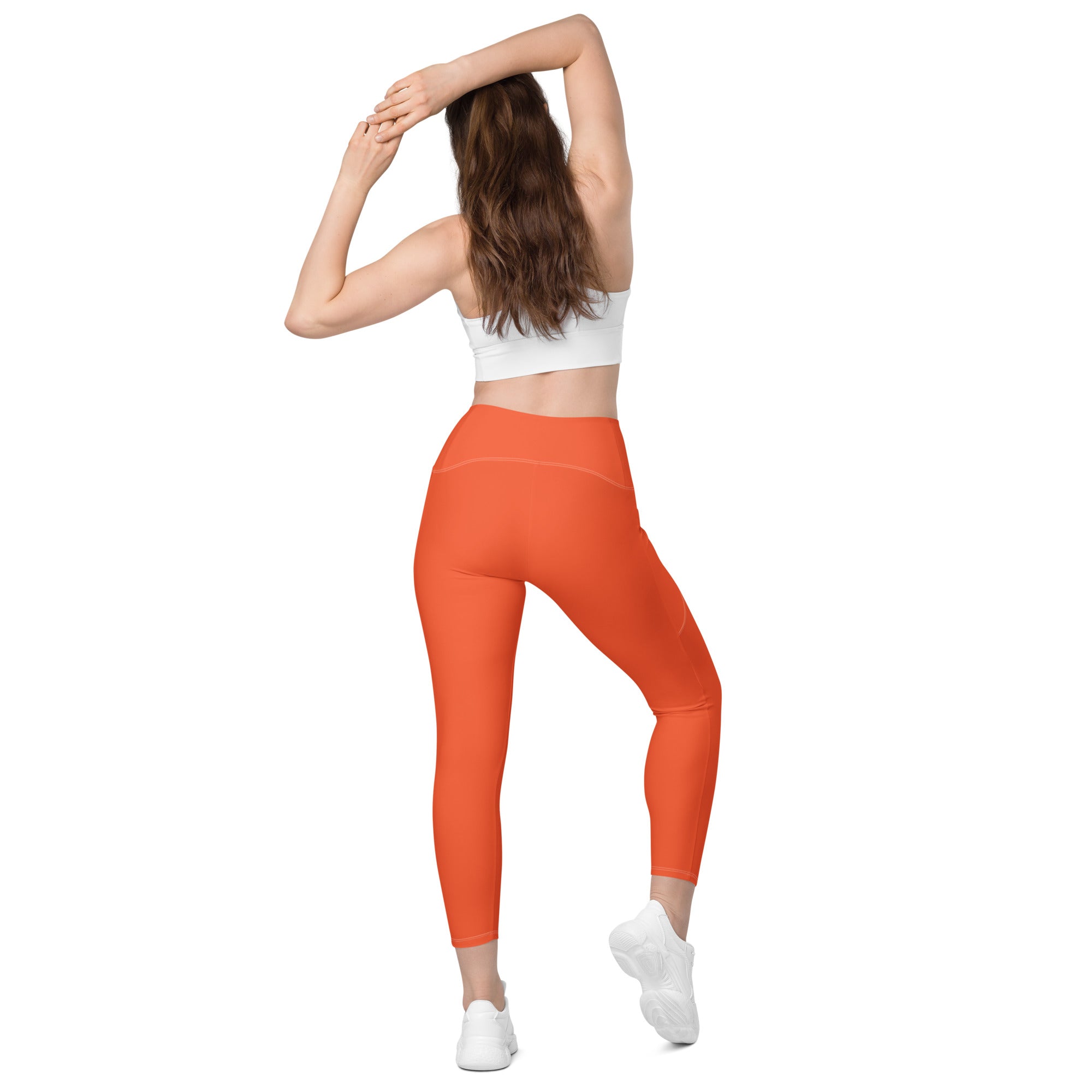 Women’s bright orange high-waisted yoga leggings with pockets featuring soft compression and a sleek form-fitting design