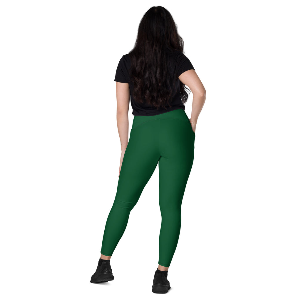 A woman wearing dark green high waisted yoga leggings with pockets made of soft compression fabric