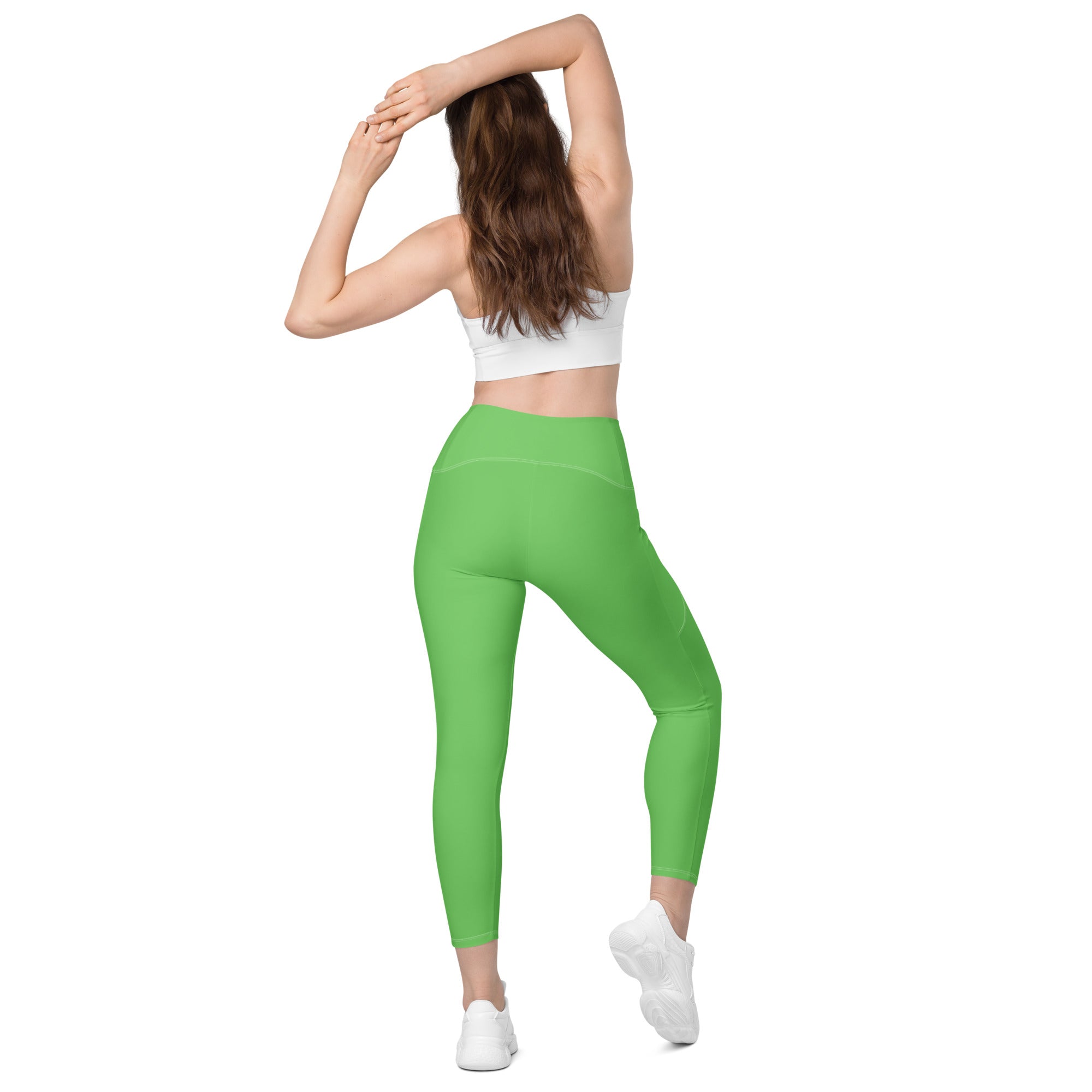 Bright green high-waisted women’s yoga leggings with pockets made of stretchy soft compression fabric