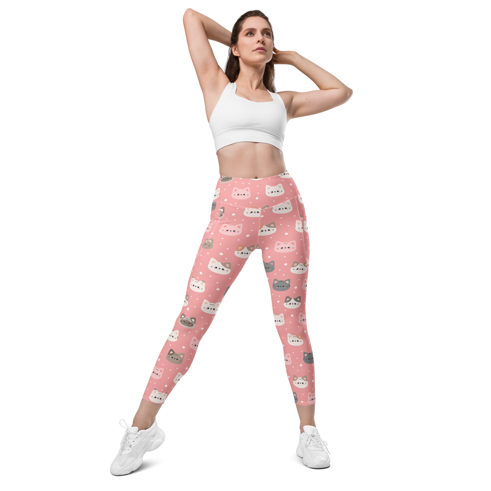 Women’s cute pink high-waisted yoga leggings with pockets featuring colorful cartoon cat faces and soft compression fabric