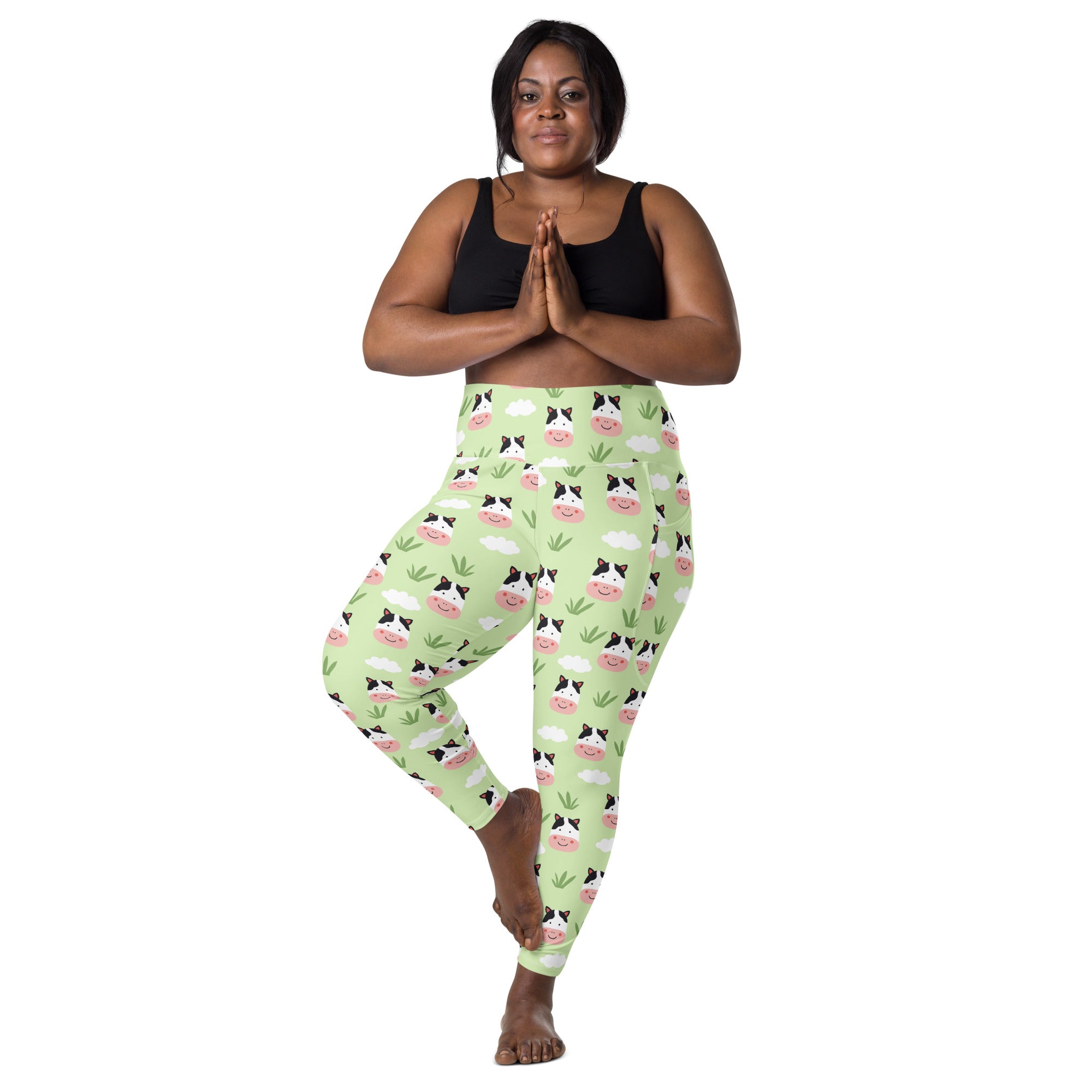Light green high waisted women’s yoga leggings with soft compression and cute cartoon cow faces clouds and grass pattern