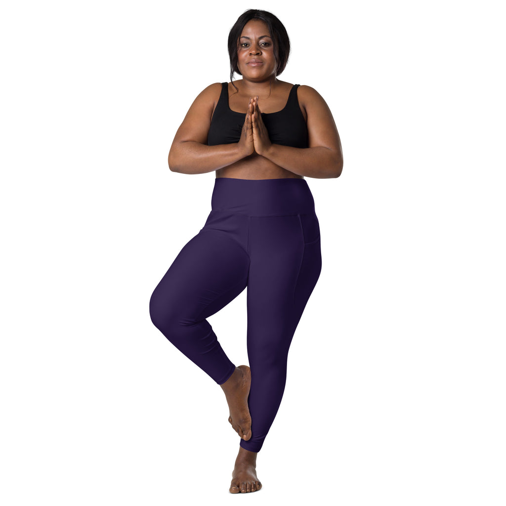 A pair of form-fitting deep purple high-waisted yoga leggings with pockets and soft compression fabric