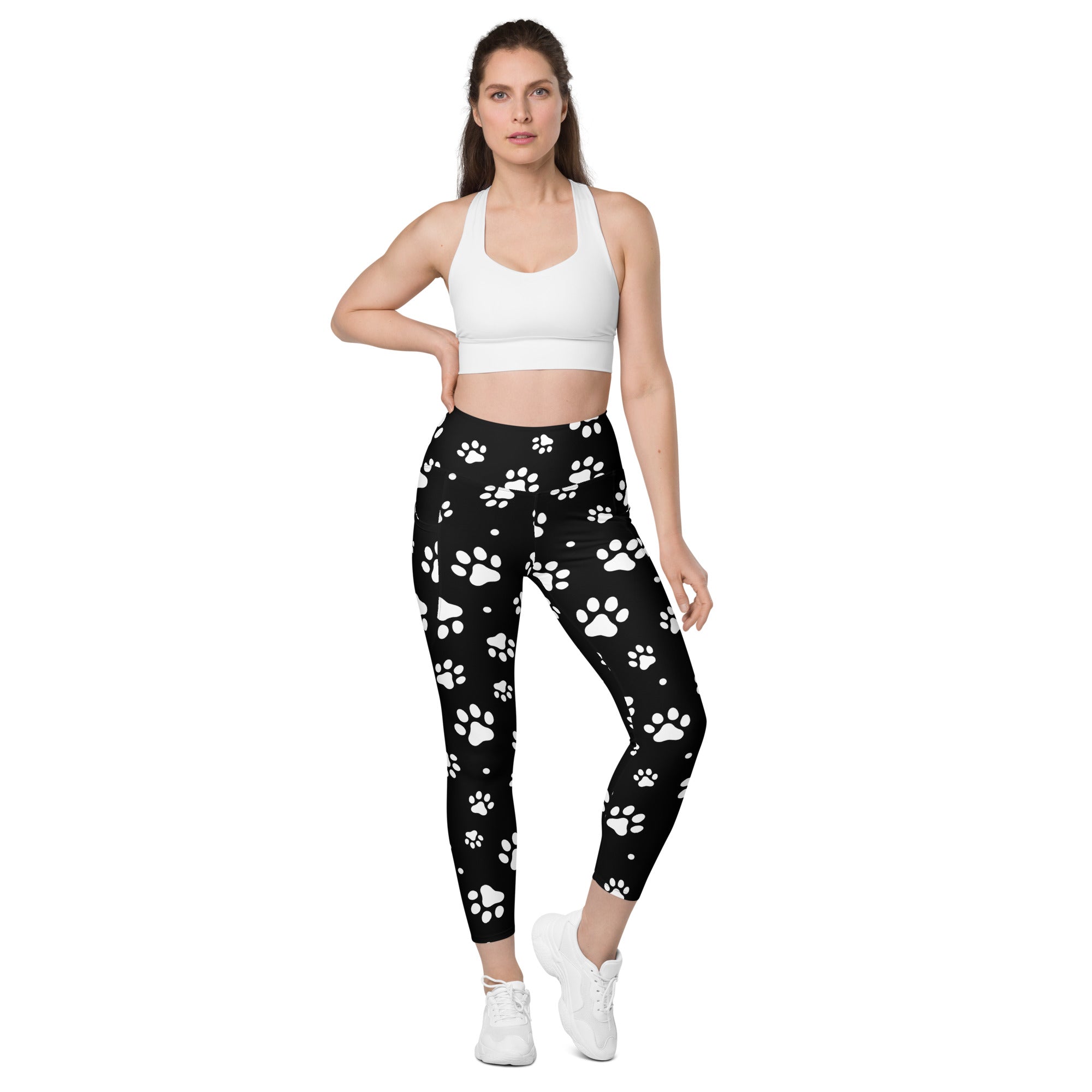 Women’s black high-waisted paw print yoga leggings with pockets featuring white paw prints and soft compression fabric