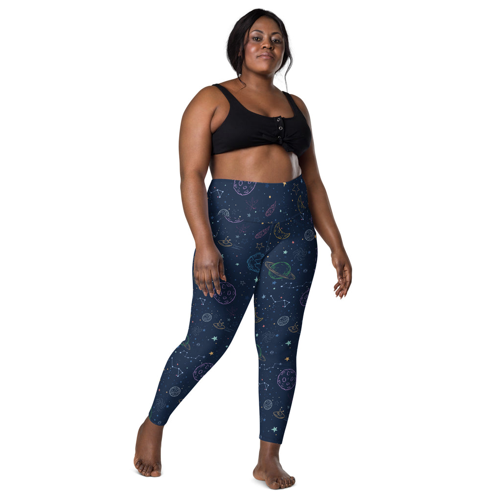 Women’s high-waisted dark blue space yoga leggings with celestial pastel designs and pockets for soft compression