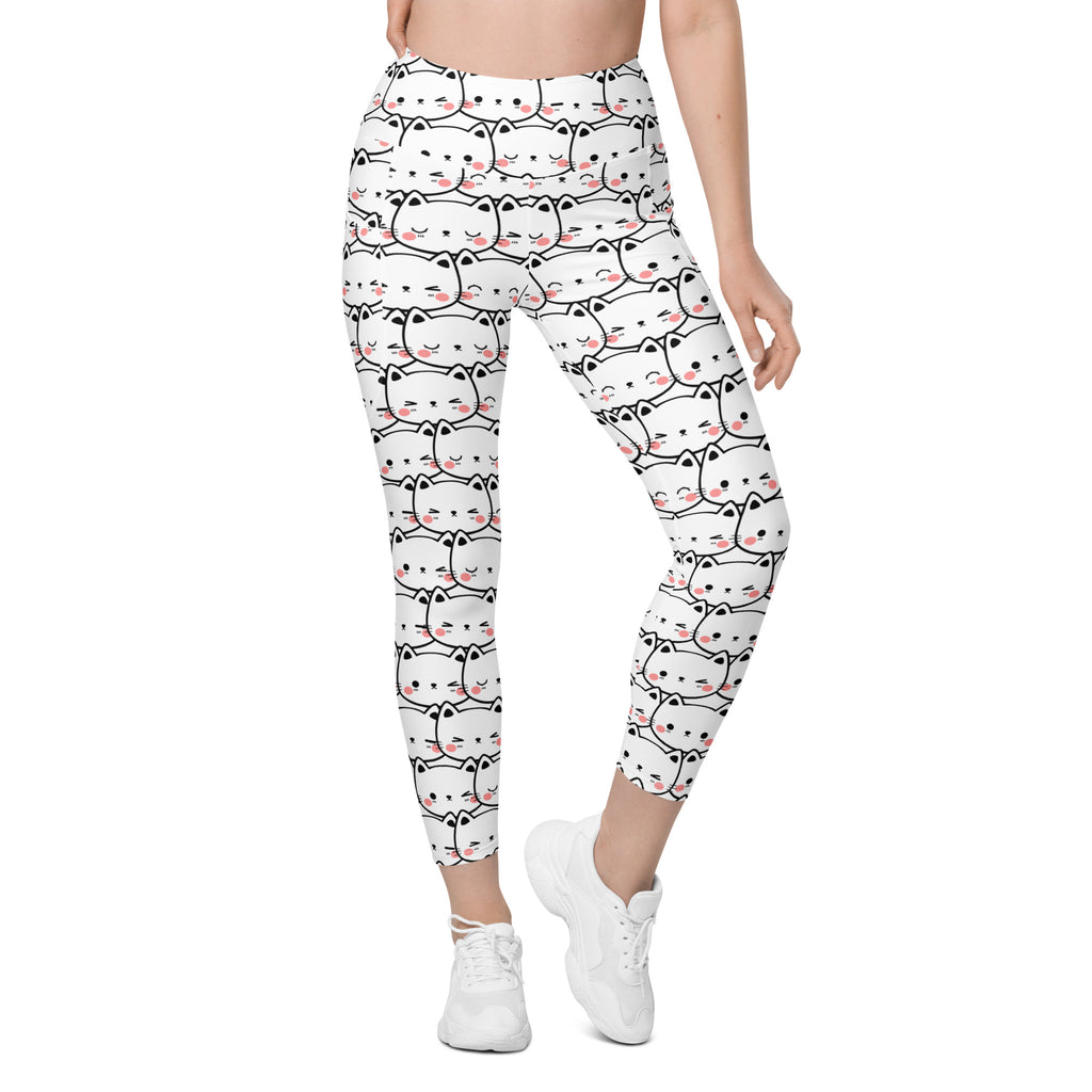 Women’s white high-waisted yoga leggings with pockets featuring a black outlined kawaii cat face pattern and soft compression