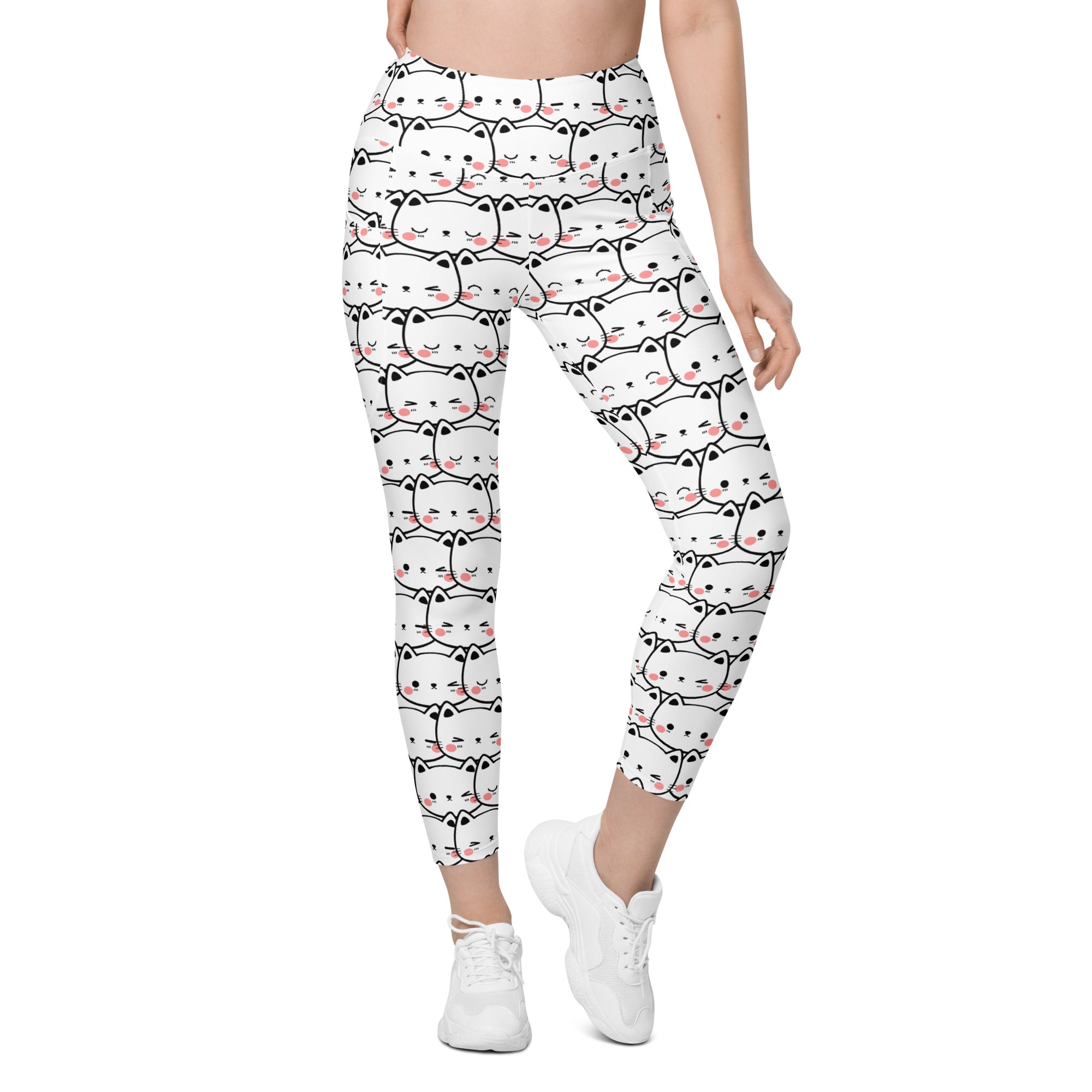 Women’s white high-waisted yoga leggings with pockets featuring a black outlined kawaii cat face pattern and soft compression