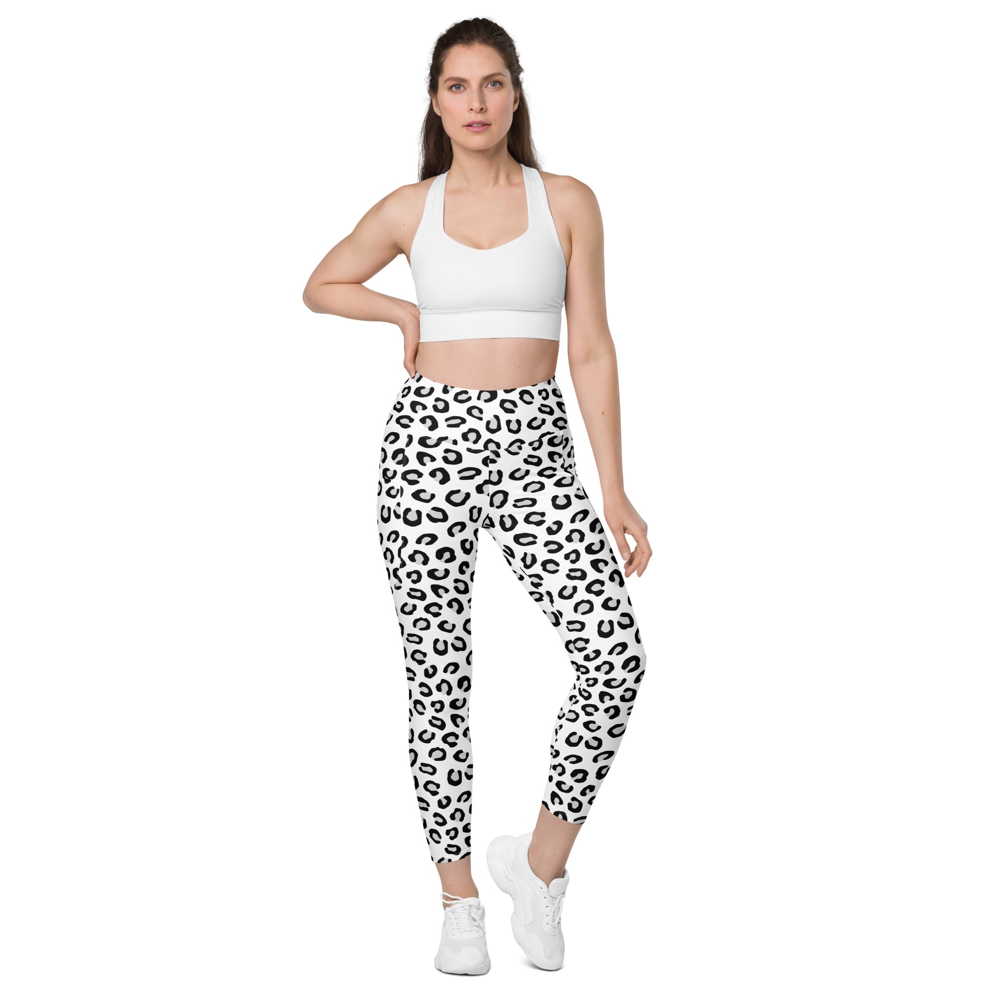 Women’s high-waisted white leggings with bold black leopard print and pockets made of soft compression fabric for yoga