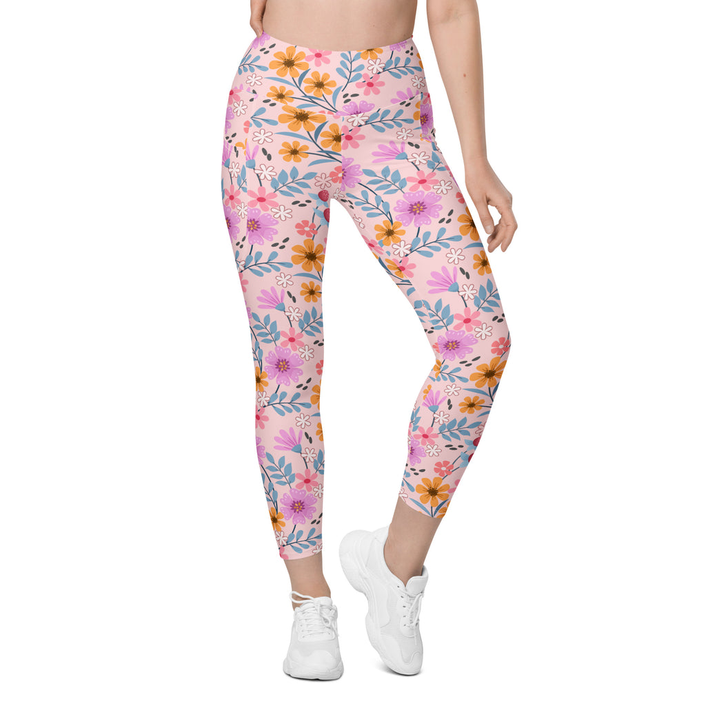 Women’s pink floral yoga leggings with pockets featuring a vibrant purple orange and blue flower pattern on soft fabric