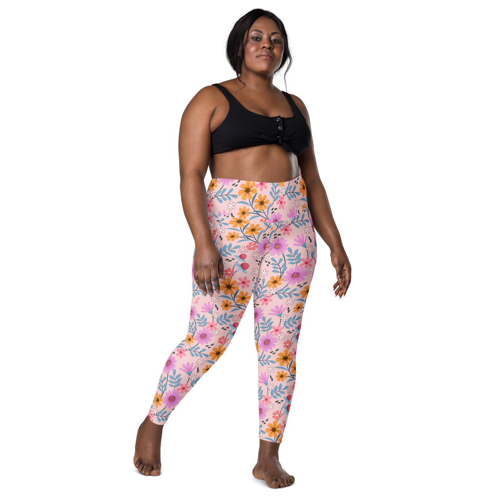 Women’s pink floral yoga leggings with pockets featuring vibrant pink orange and blue flower and leaf pattern