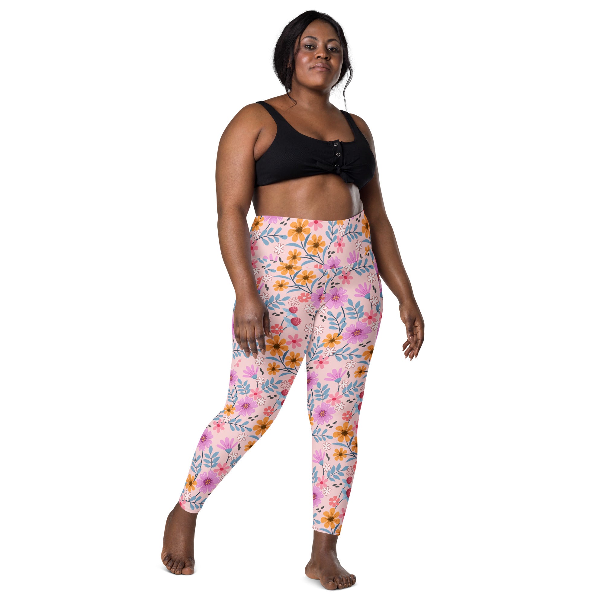 Women’s pink floral yoga leggings with pockets featuring vibrant pink orange and blue flower and leaf pattern