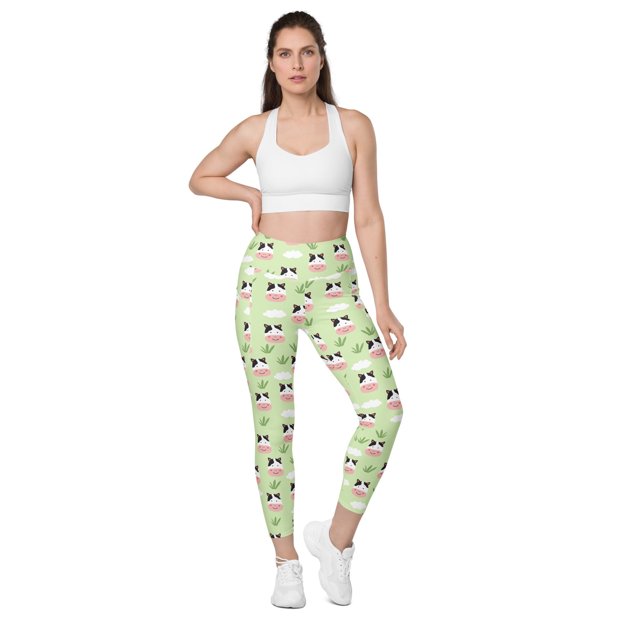 Women’s light green cute cow yoga leggings with pockets featuring cartoon cows clouds and grass pattern