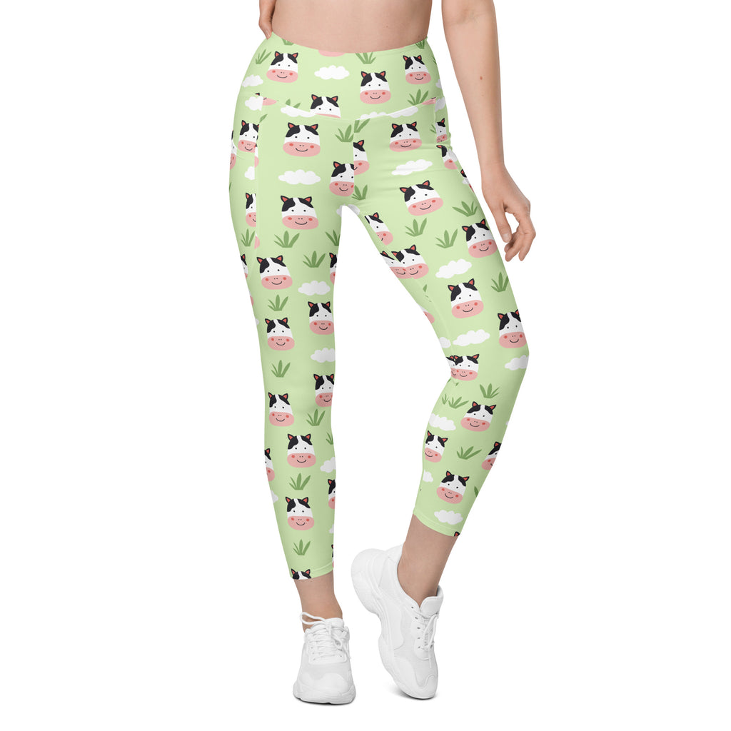 Women’s light green high-waisted yoga leggings with pockets featuring soft compression and a playful cow pattern