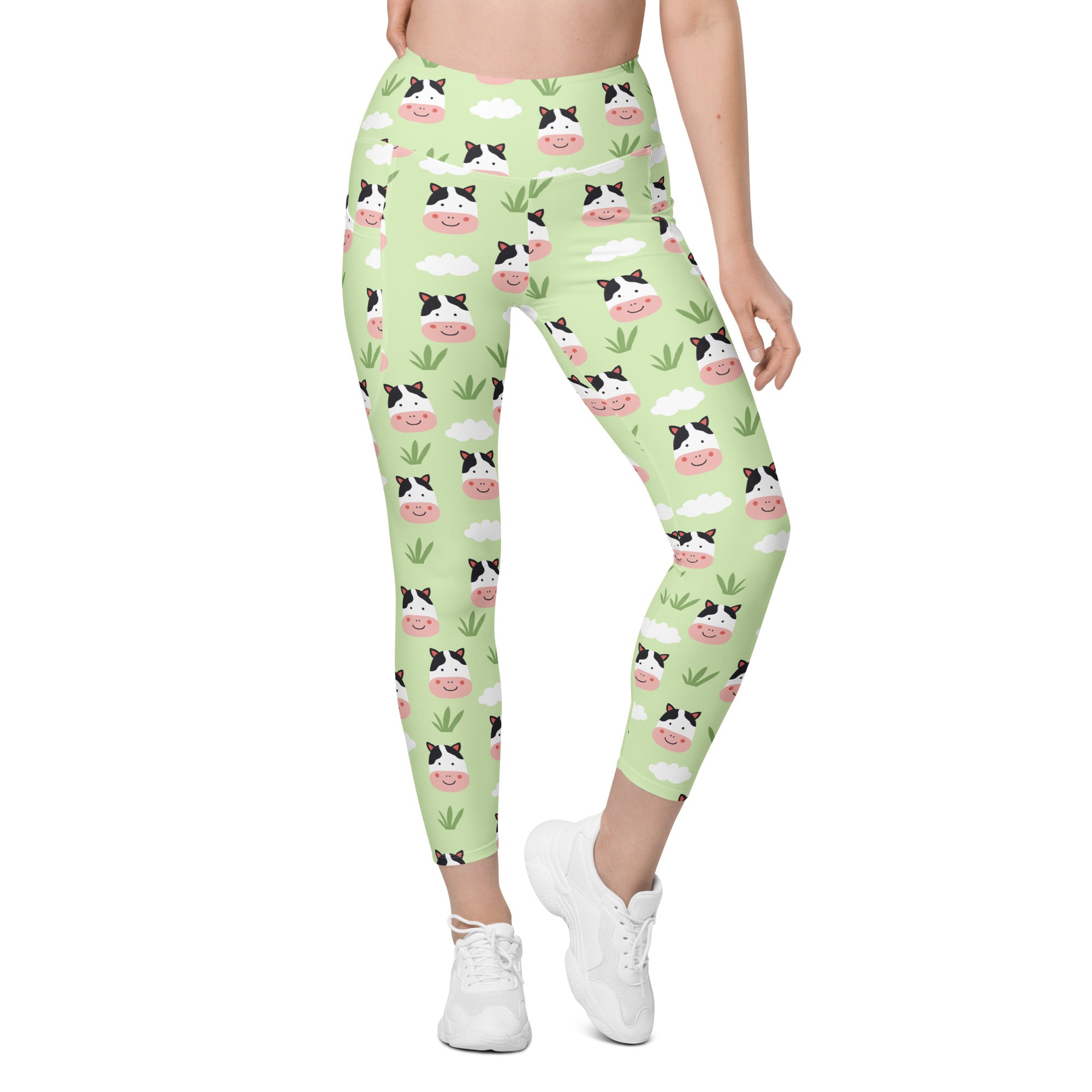Women’s light green high-waisted yoga leggings with pockets featuring soft compression and a playful cow pattern