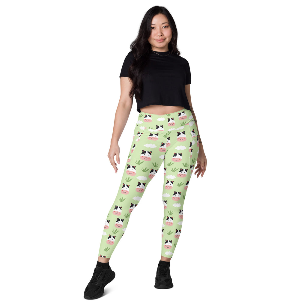 Women’s light green high-waisted yoga leggings with soft compression featuring cute cartoon cow faces and grass pattern