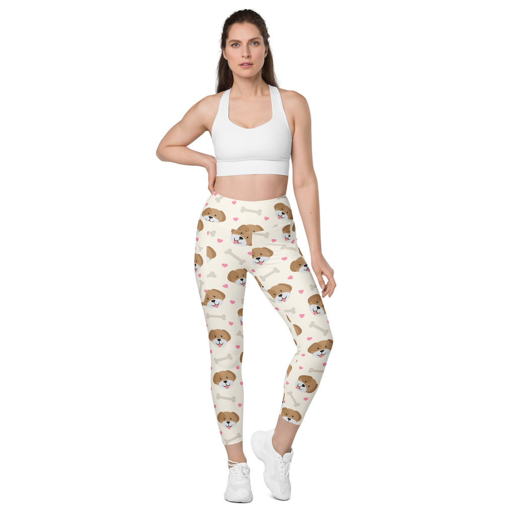 Women’s cream-colored cute dog yoga leggings with pockets featuring brown puppy faces and white bones pattern