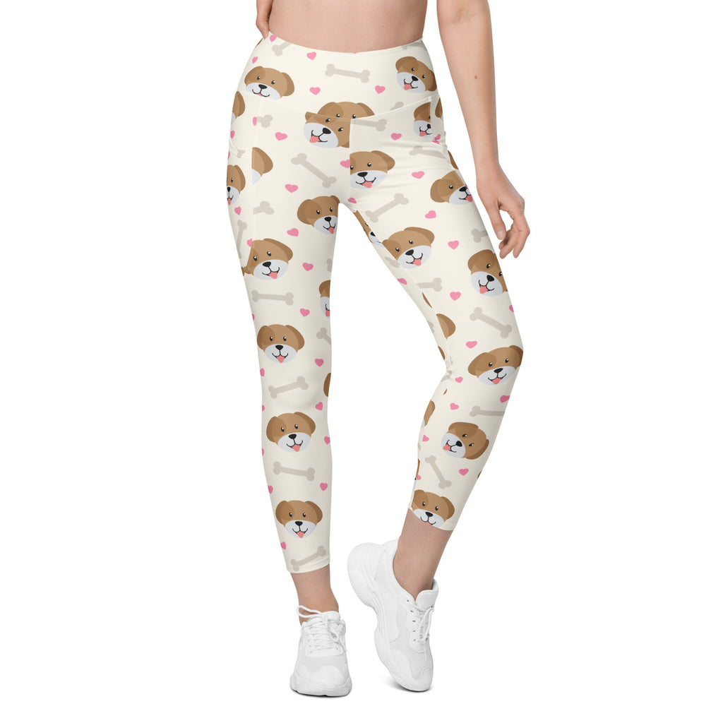 Cream-colored women’s high-waisted cute dog yoga leggings with pockets featuring playful puppy faces pink hearts and bones