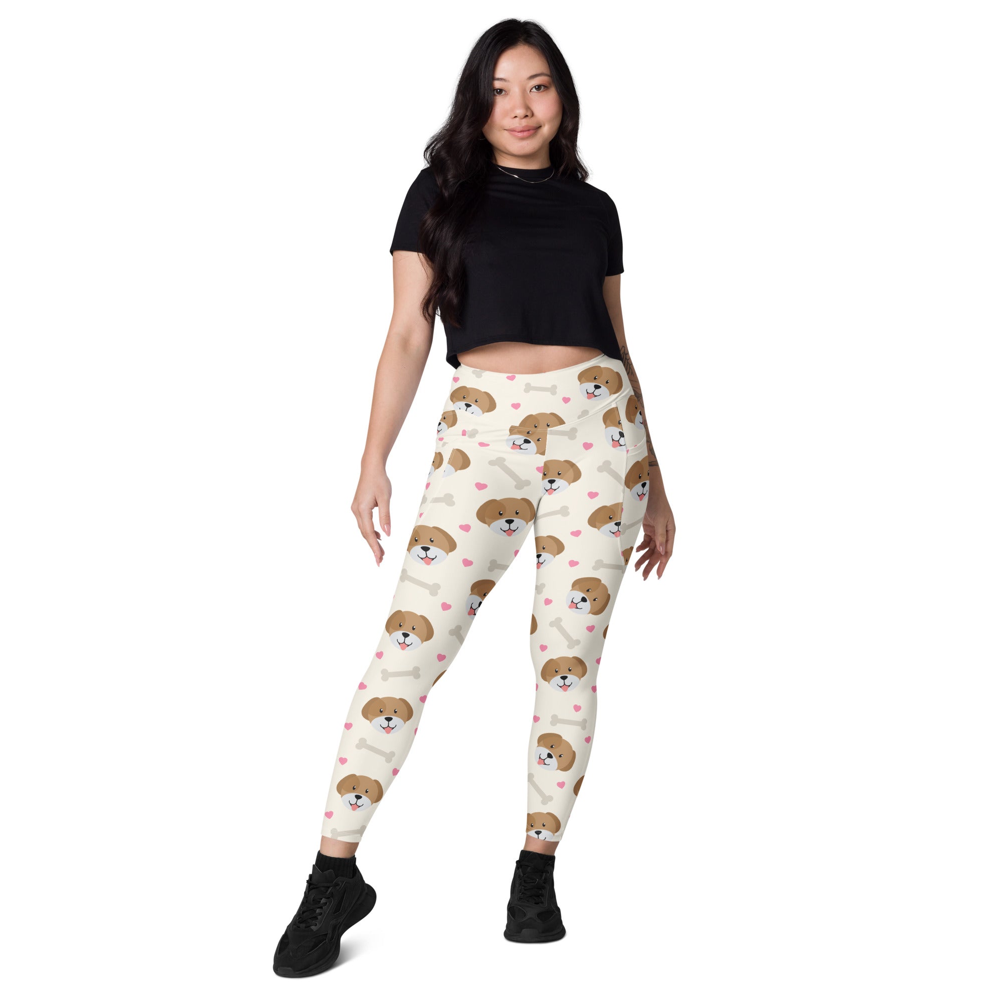 Cream-colored women’s dog yoga leggings with pockets featuring brown puppy faces pink hearts and white bones pattern
