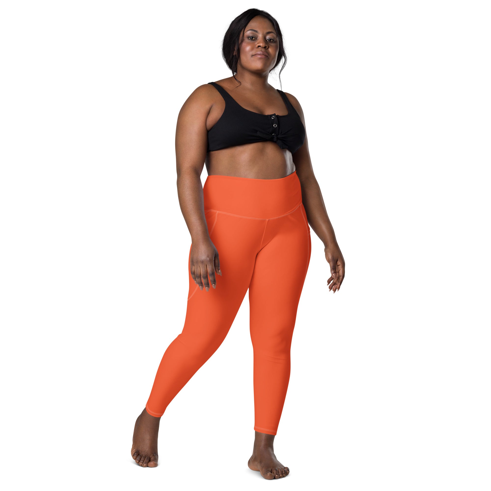 Women’s bright orange high-waisted yoga leggings with pockets made of soft compression fabric for active wear