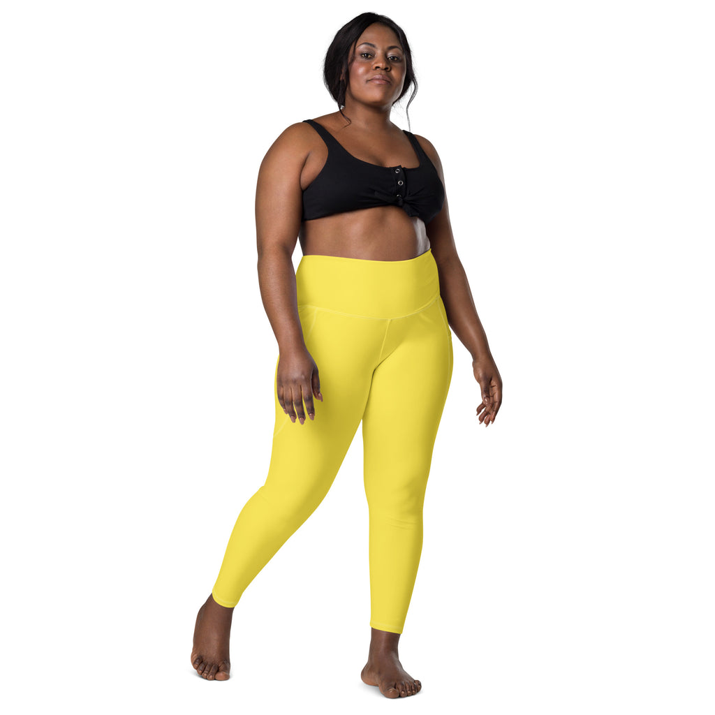 Bright yellow high-waisted women’s yoga leggings with pockets made of soft compression fabric for active wear