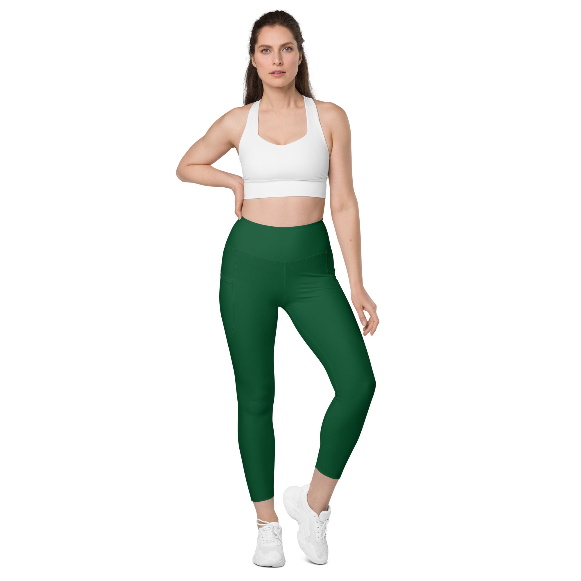 Women’s dark green high-waisted yoga leggings with pockets made of smooth stretchy fabric and cropped hemline
