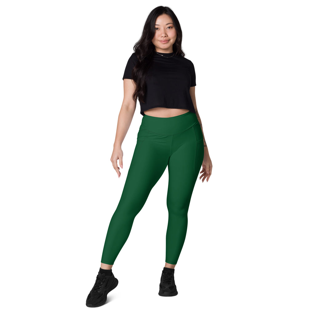 A pair of solid emerald green high-waisted yoga leggings with soft compression and pockets for women