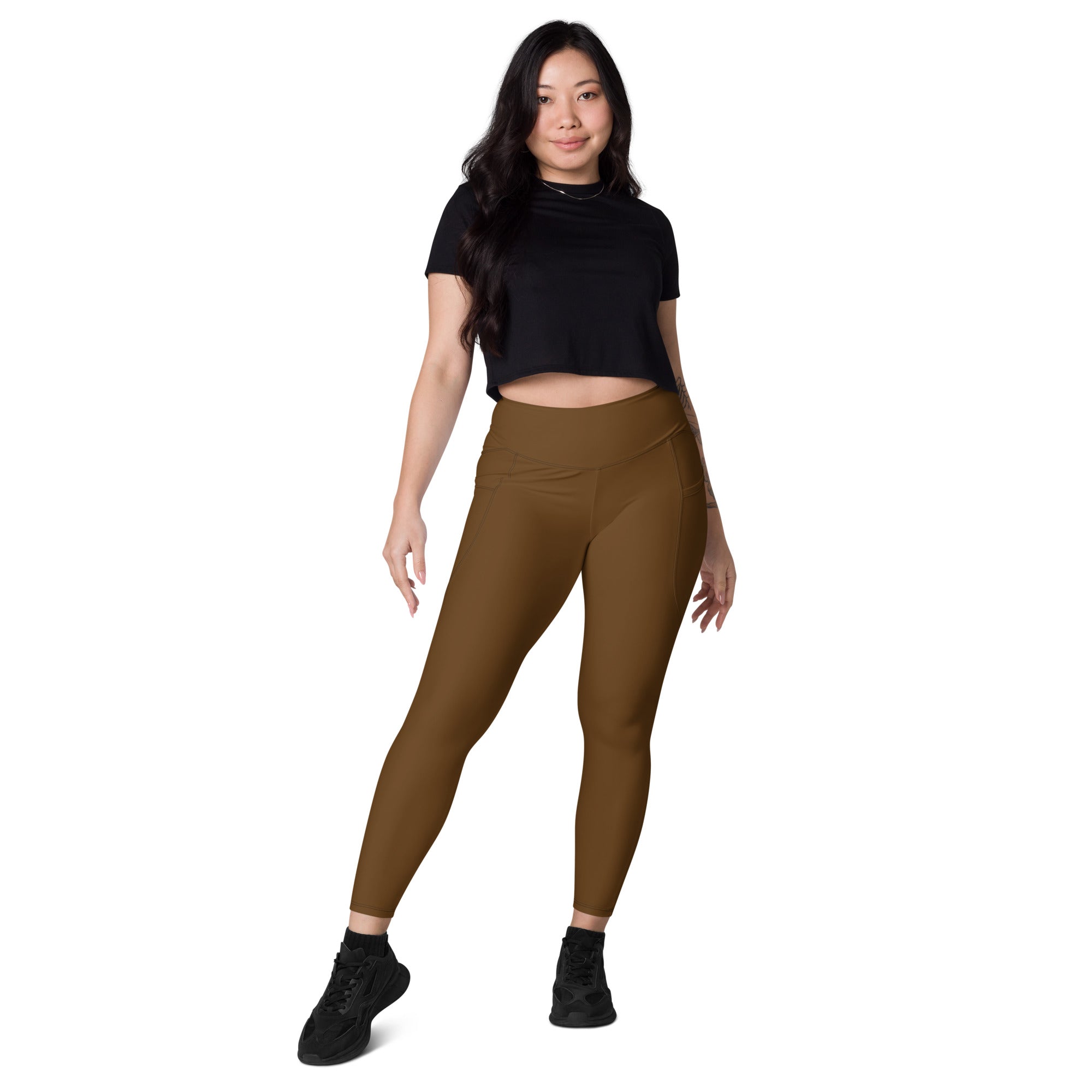 A pair of women’s high-waisted brown yoga leggings with pockets made from soft stretchy compression fabric