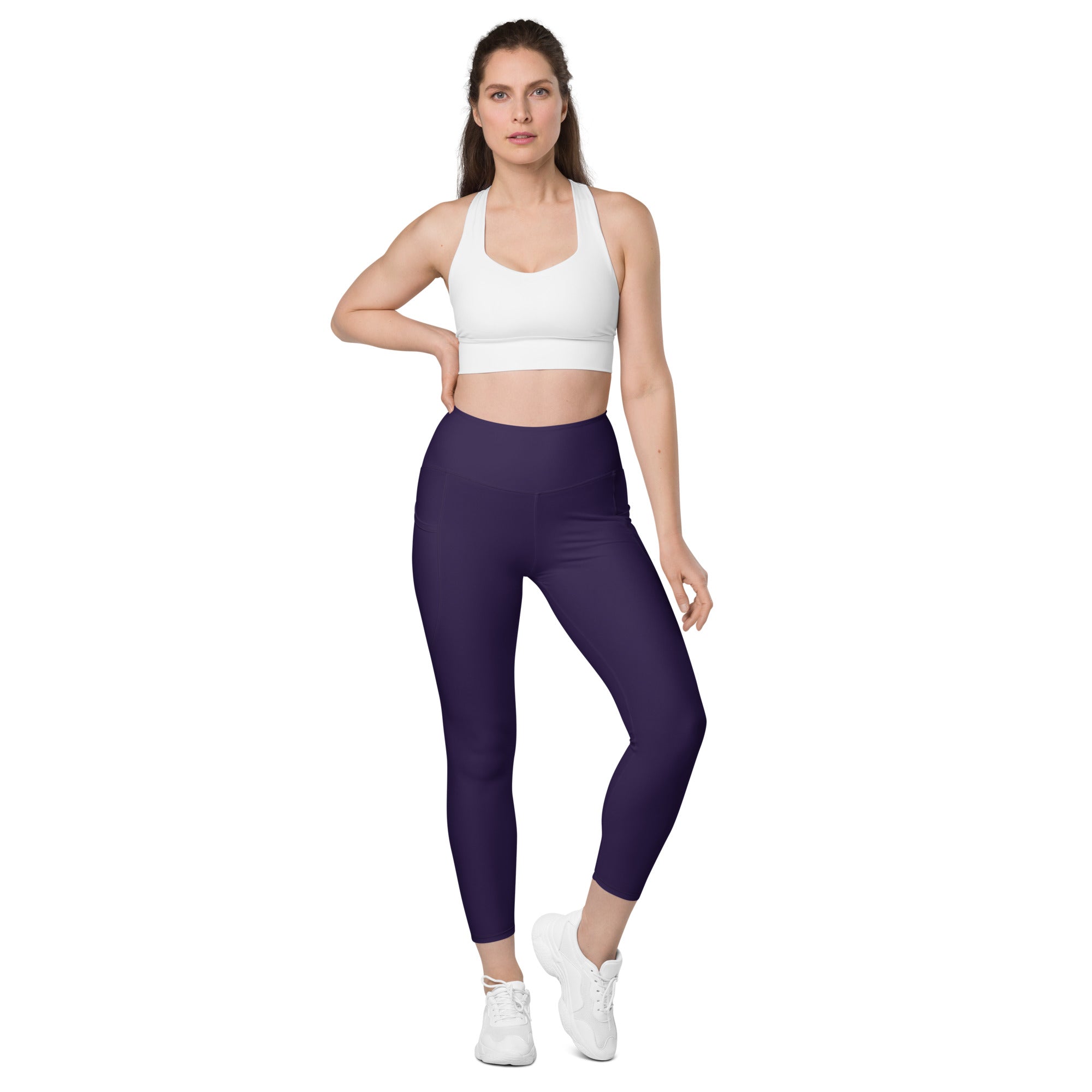 A pair of high-waisted dark purple yoga leggings with pockets made of soft compression stretchy fabric