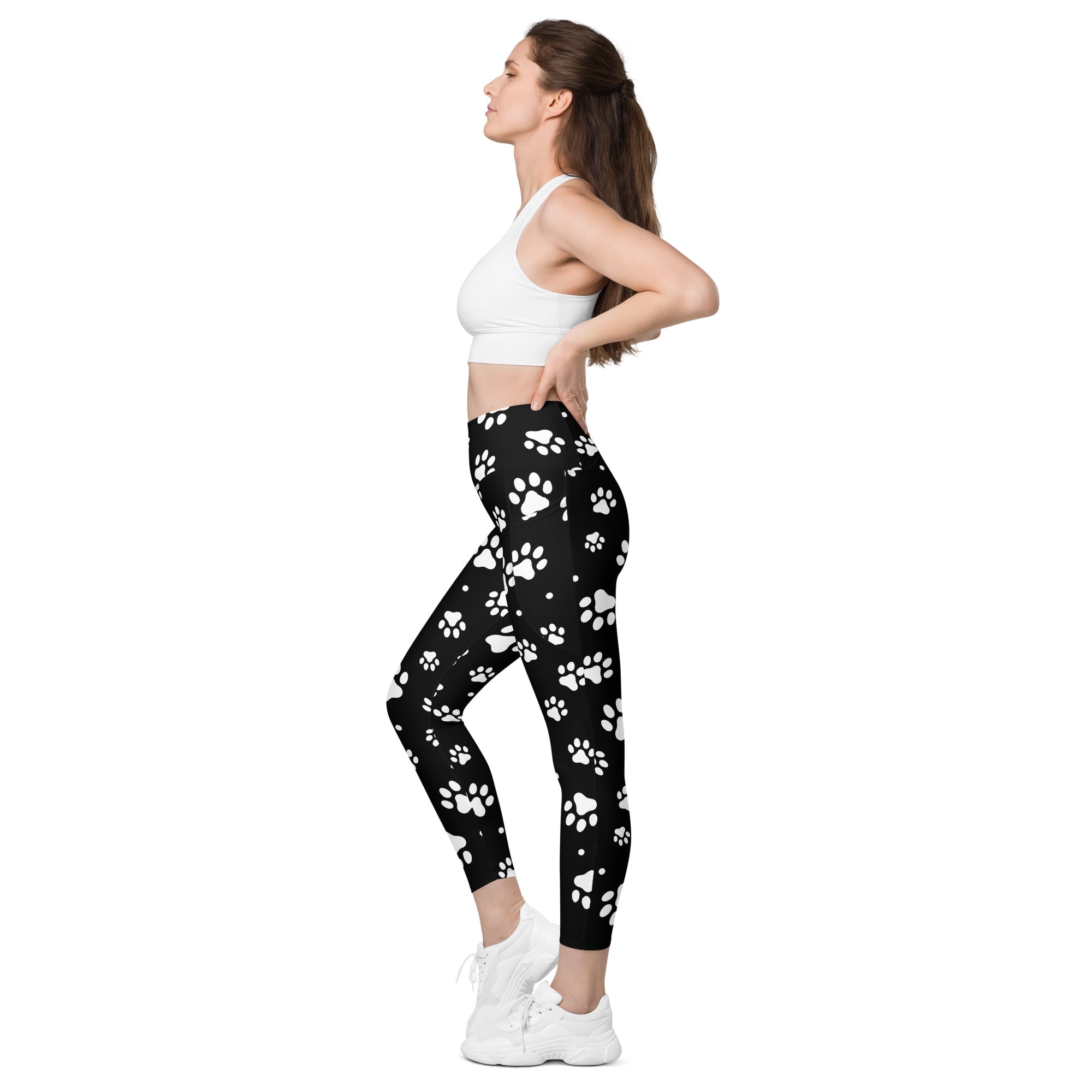 Women’s black high-waisted paw print yoga leggings with pockets featuring soft compression fabric and white paw prints