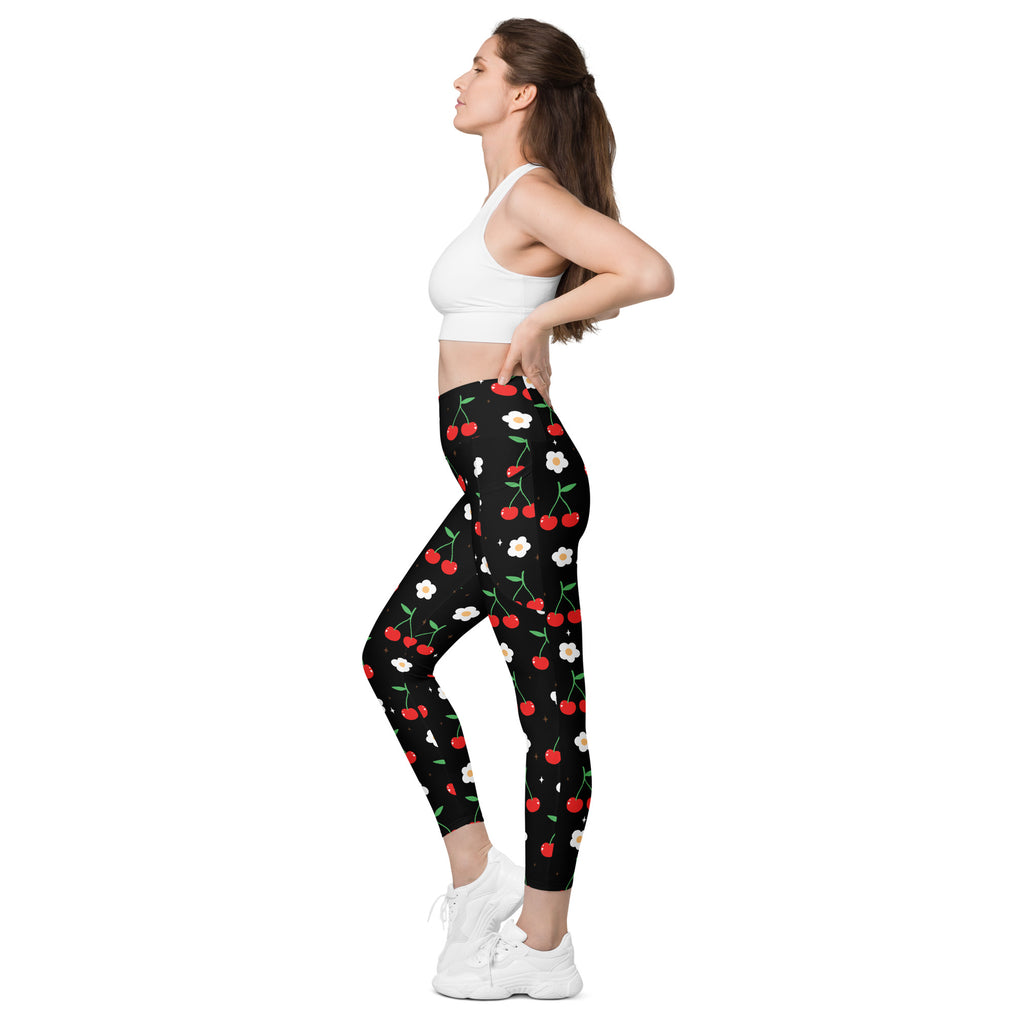 Black high-waisted women’s cherry print yoga leggings with pockets featuring red cherries and white flowers pattern