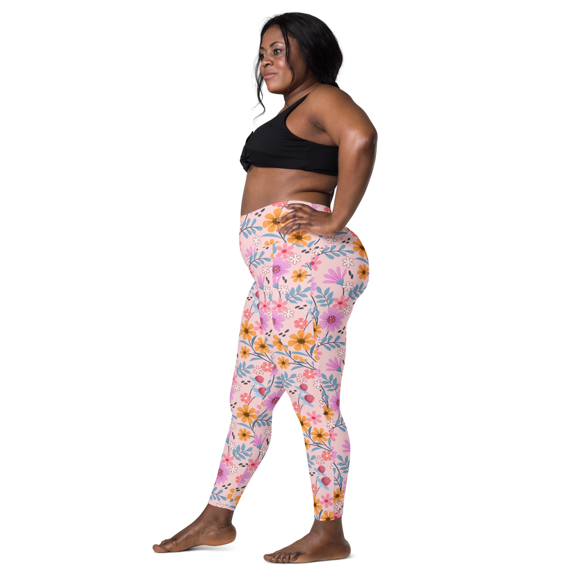 Women’s pink floral yoga leggings with pockets featuring vibrant yellow purple and blue flowers on soft compression fabric