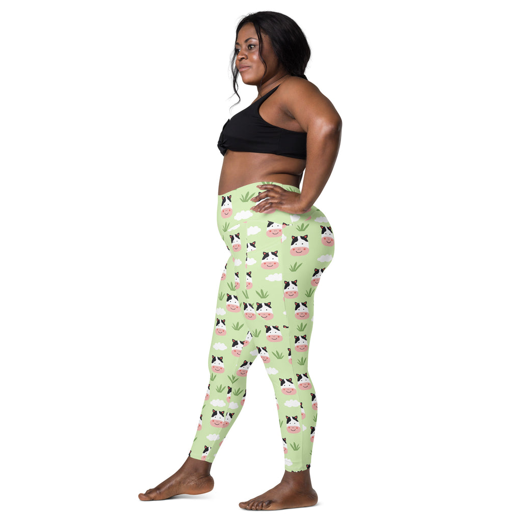 Light green high-waisted women’s cute cow yoga leggings with pockets featuring cartoon cow faces clouds and grass pattern
