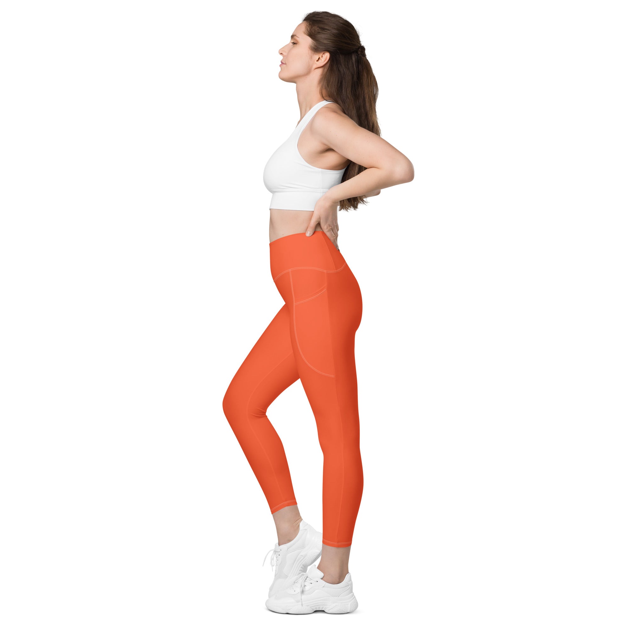 Women’s orange high-waisted yoga leggings with soft compression fabric and subtle side pockets for active wear