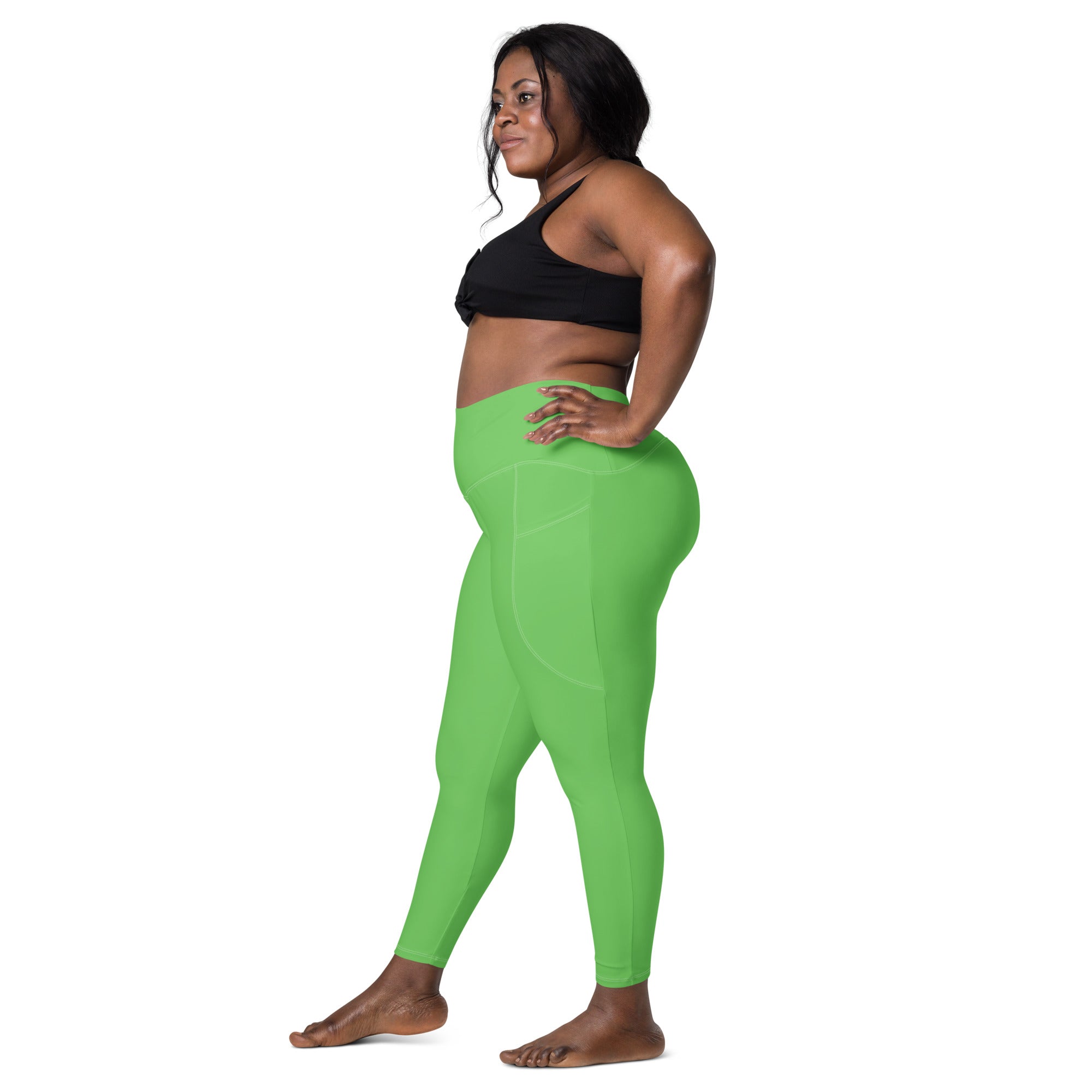 Women’s green high-waisted yoga leggings with pockets made of soft, smooth, form-fitting compression material