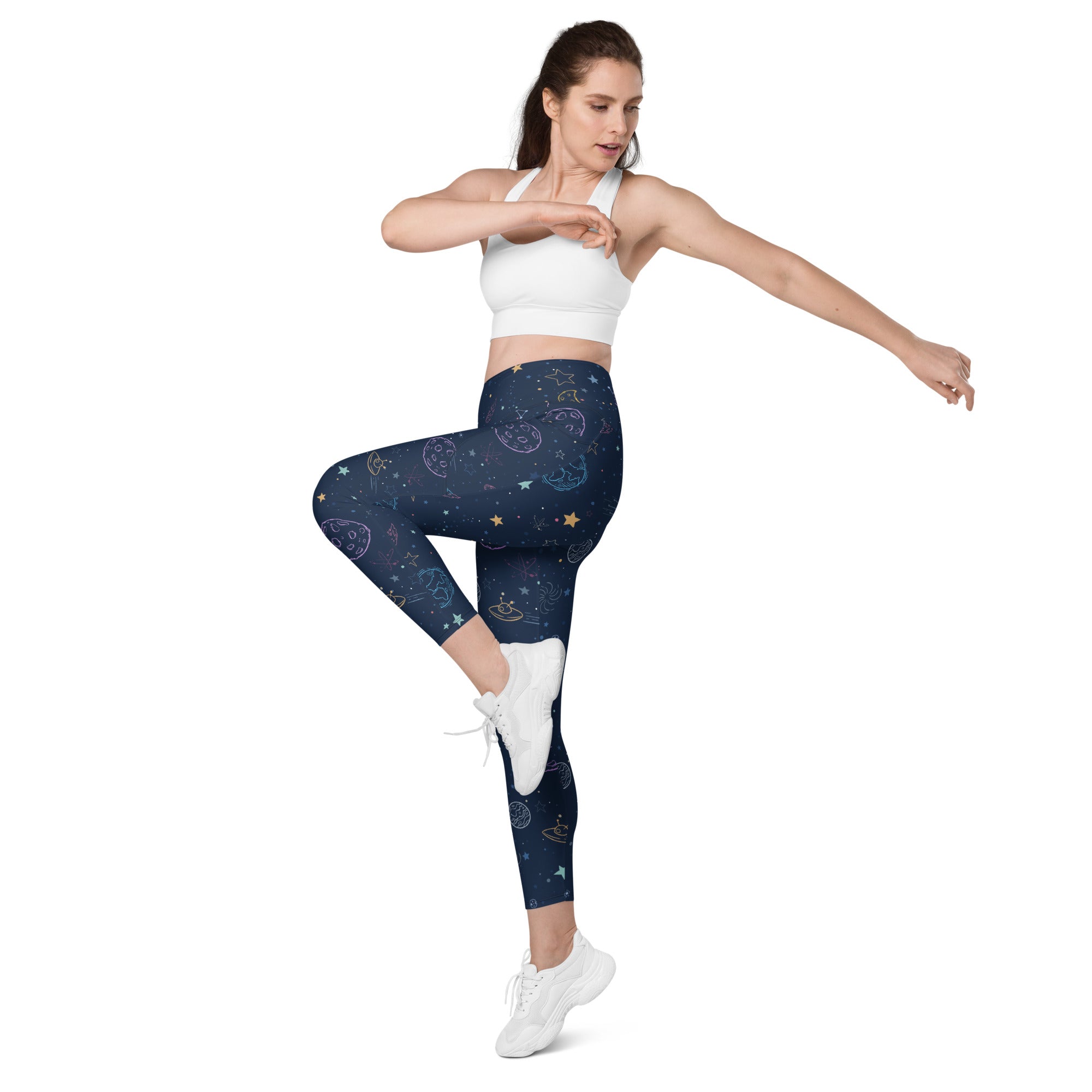 Women’s high-waisted dark blue galaxy space leggings with celestial white gold and teal patterns and pockets for yoga