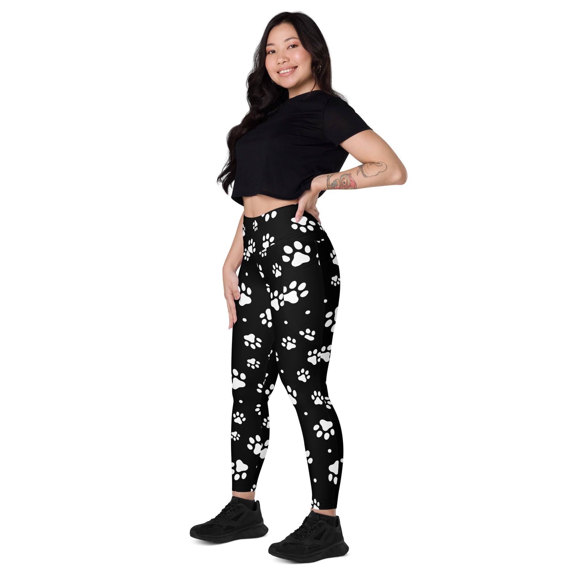 Black women’s high-waisted yoga leggings with soft compression and white paw print pattern with pockets