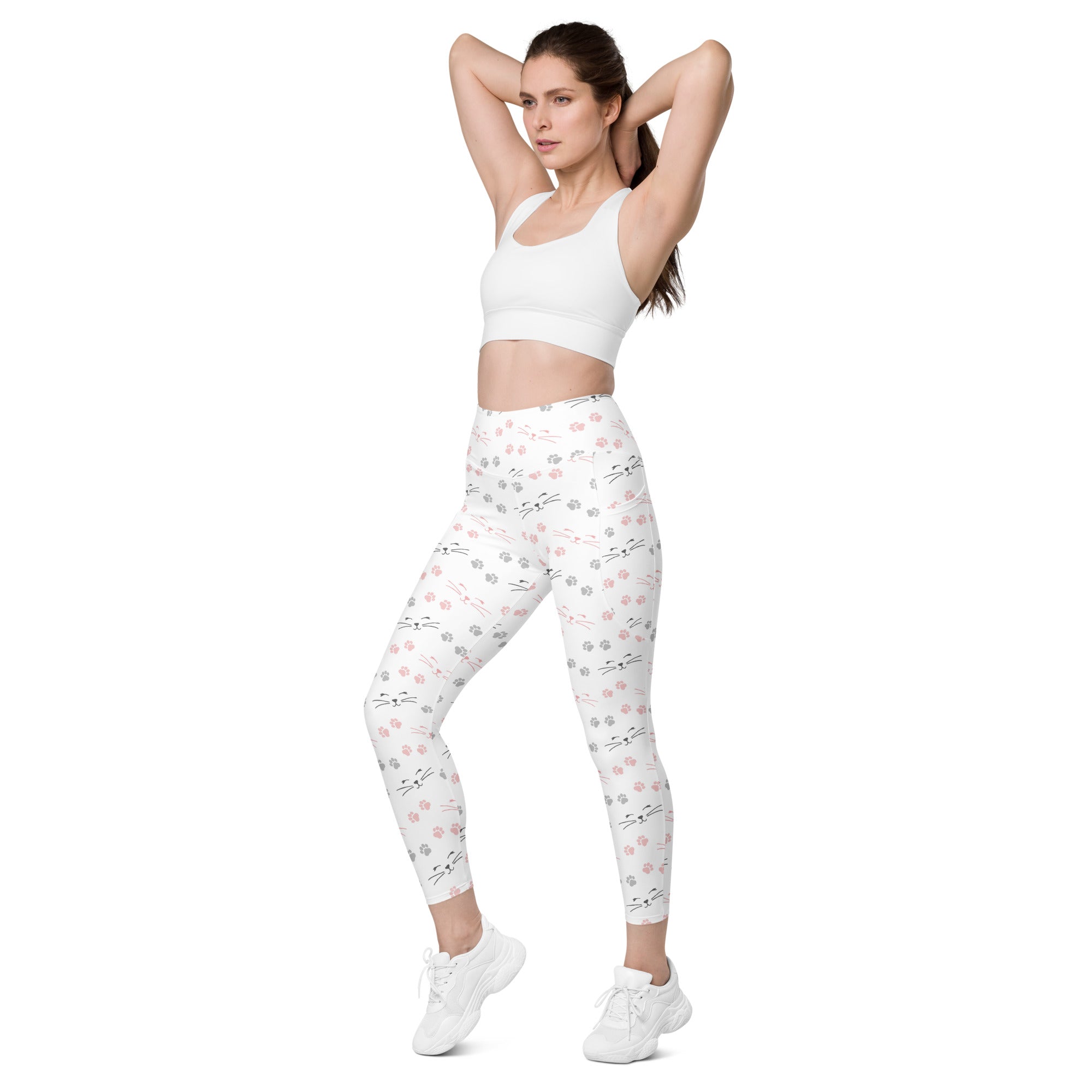 White high-waisted yoga leggings with soft compression featuring a playful pink and gray cat face pattern and pockets