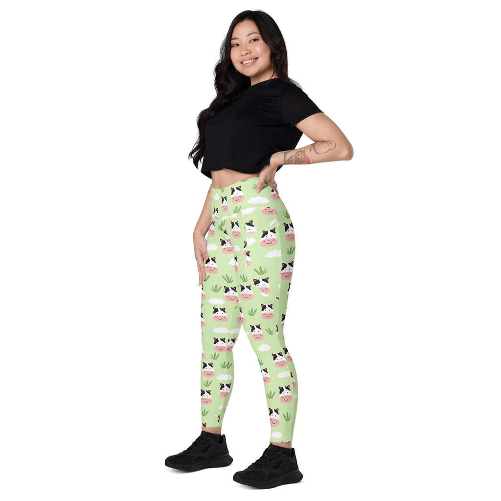 Women’s light green high-waisted cute cow yoga leggings with pockets featuring cartoon cows clouds and grass pattern