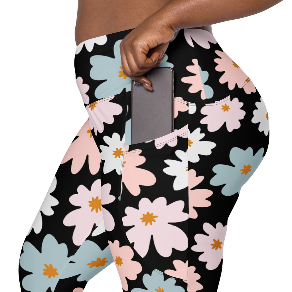 Women’s high-waisted black leggings with vibrant pink white blue floral pattern and orange centers featuring pockets