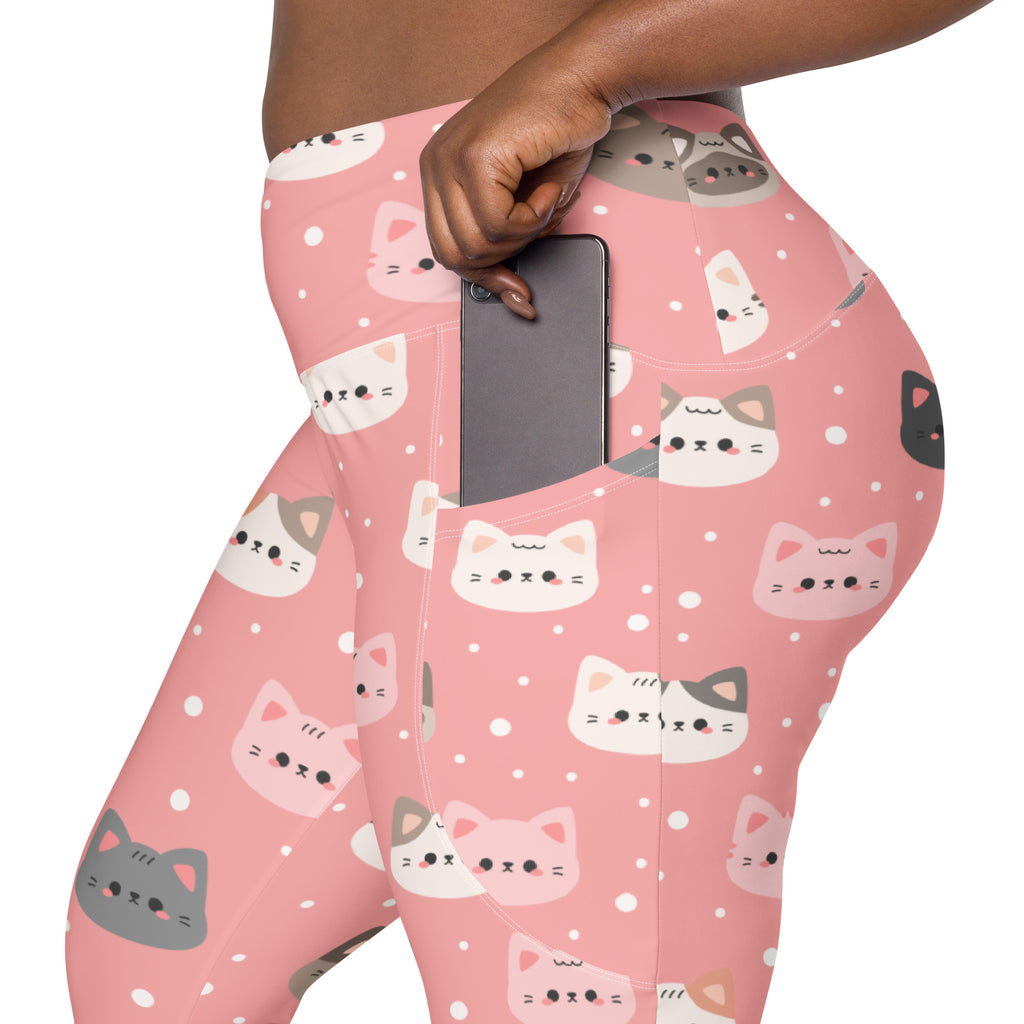Women’s high-waisted pink yoga leggings with pockets featuring playful white gray and black cartoon cat faces and polka dots