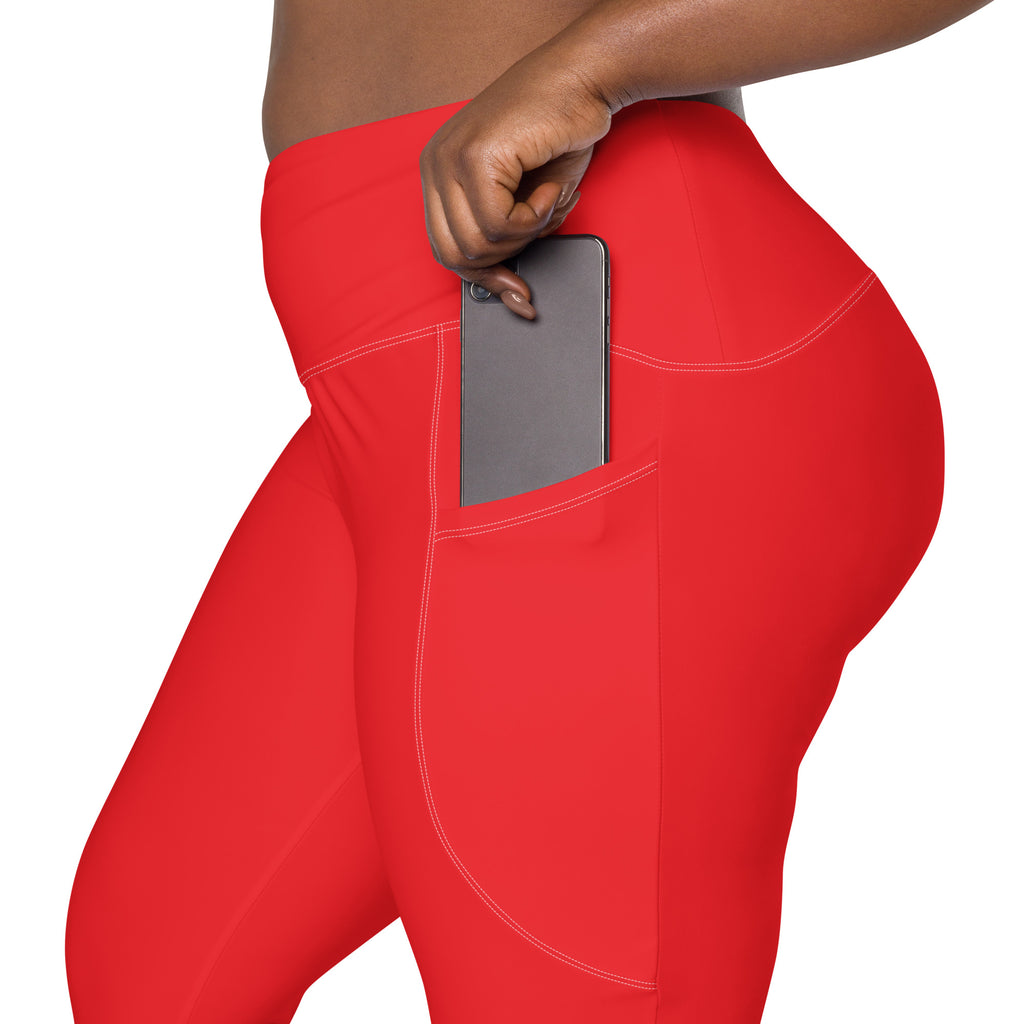 Women’s red high-waisted yoga leggings with soft compression and side pocket holding a smartphone