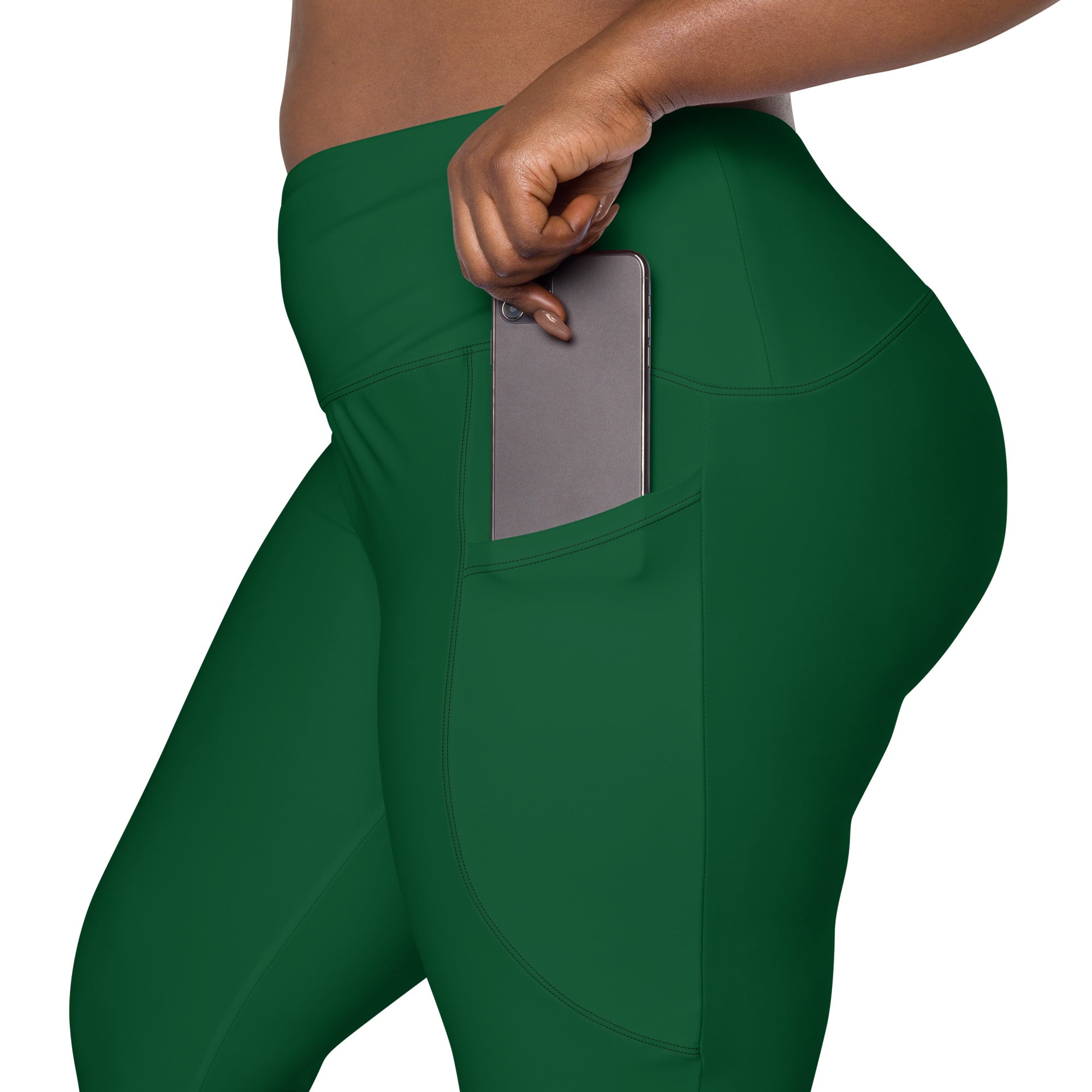 Women’s dark green high-waisted yoga leggings with soft compression fabric and side pocket holding a smartphone