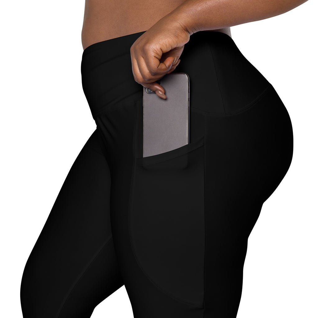 Women’s black high-waisted yoga leggings with soft compression fabric and a side pocket holding a smartphone