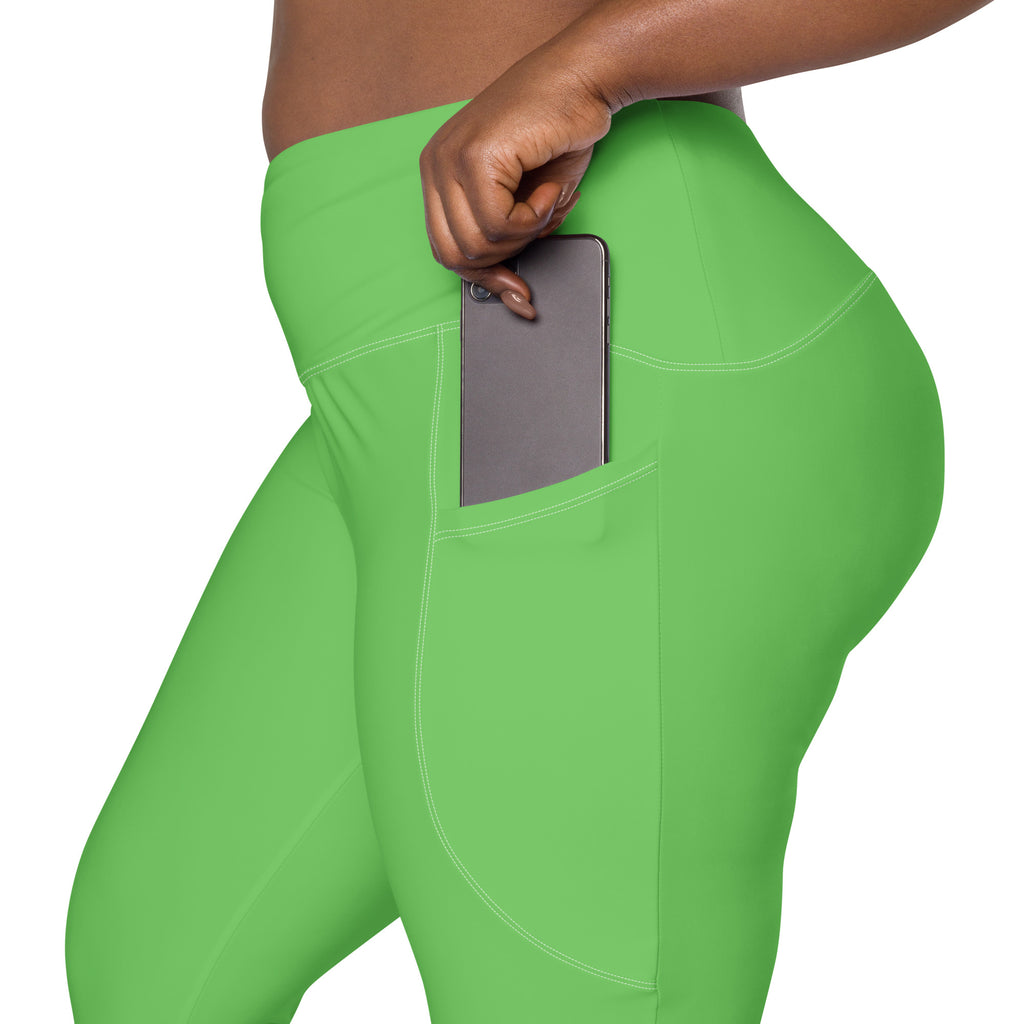 Bright green high-waisted women’s yoga leggings with soft compression and a side pocket holding a smartphone