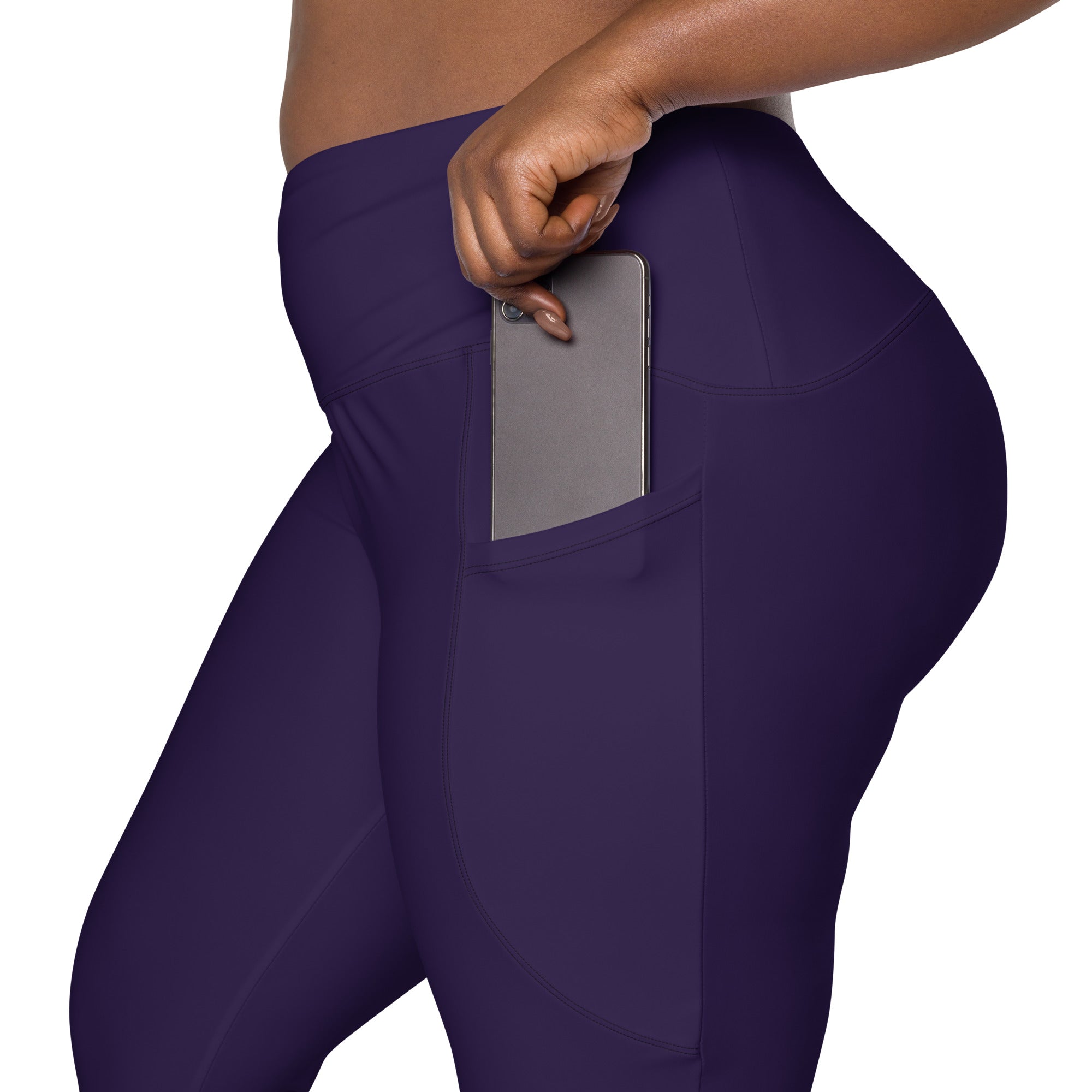 Women’s dark purple high-waisted yoga leggings with soft compression fabric and a side pocket holding a smartphone